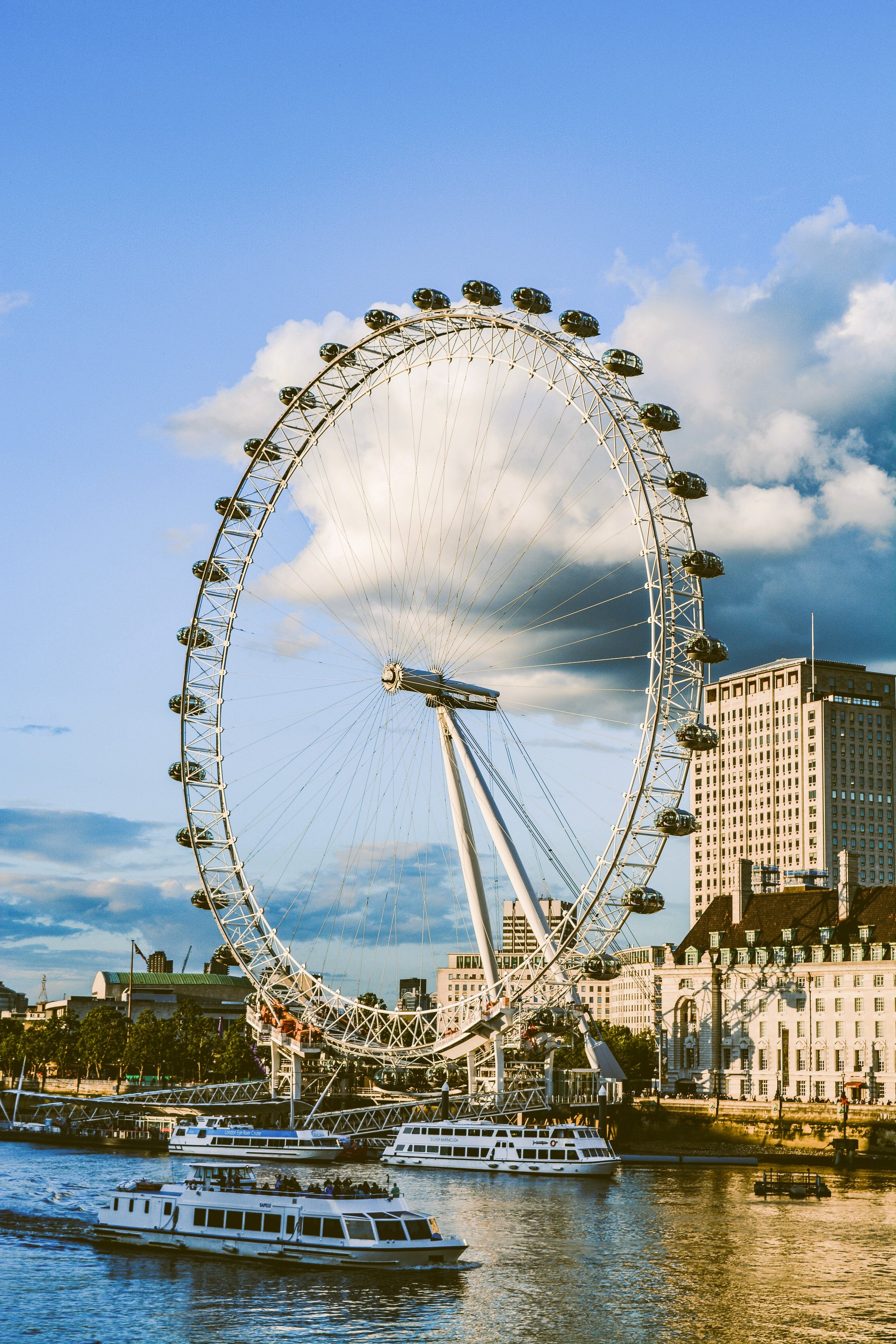 The London Eye ferris wheel rising above the River Thames at dusk