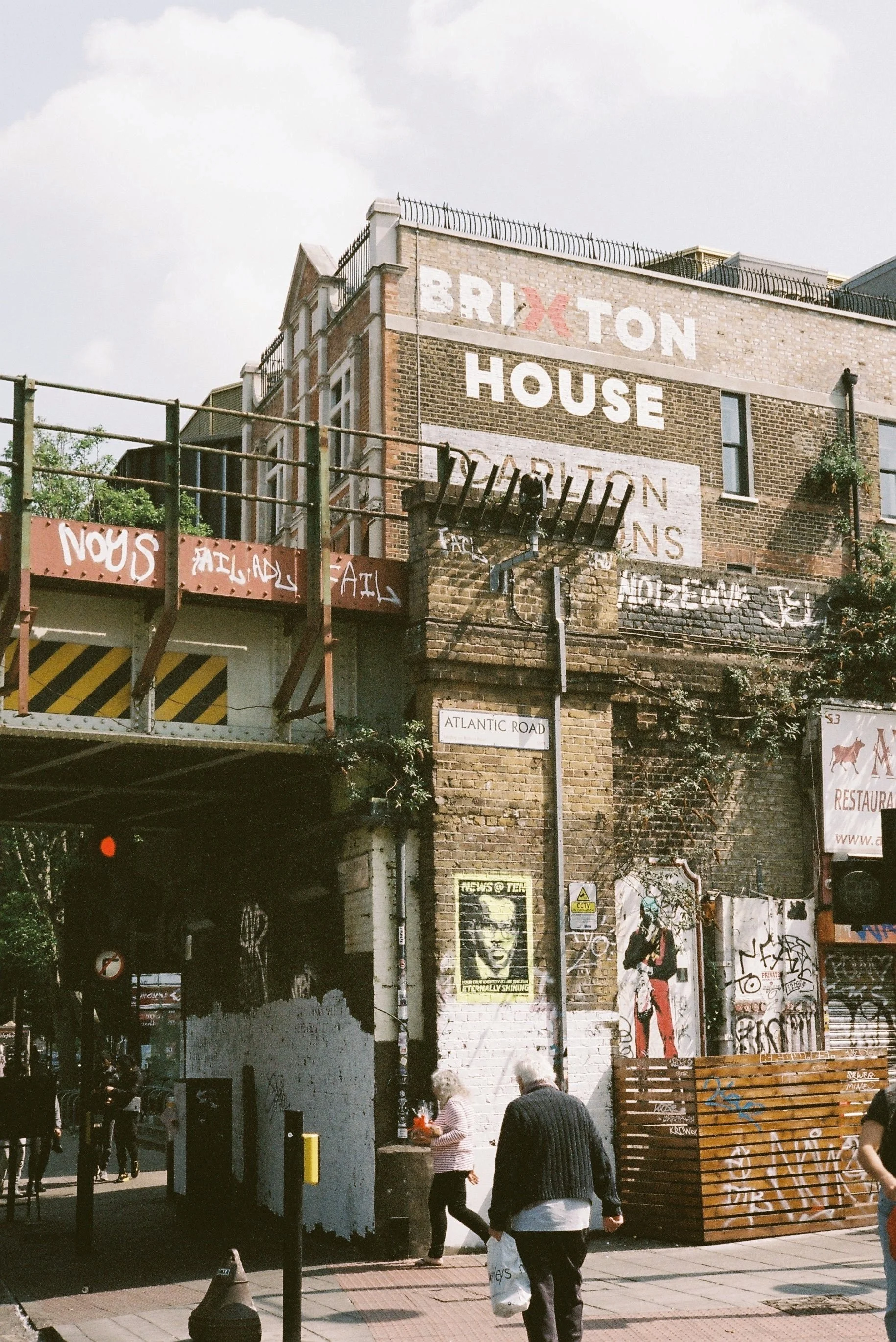 Graffiti-covered building with an outdoor terrace, Brixton, London.