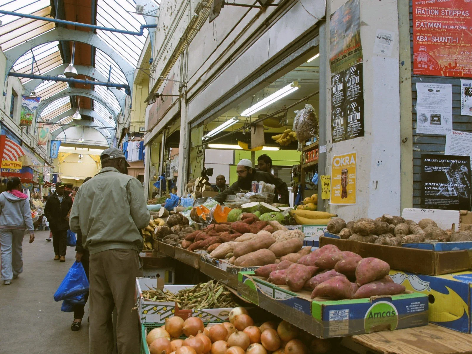 Covered market stalls with fresh fruit and vegetables, Brixton Market, London.