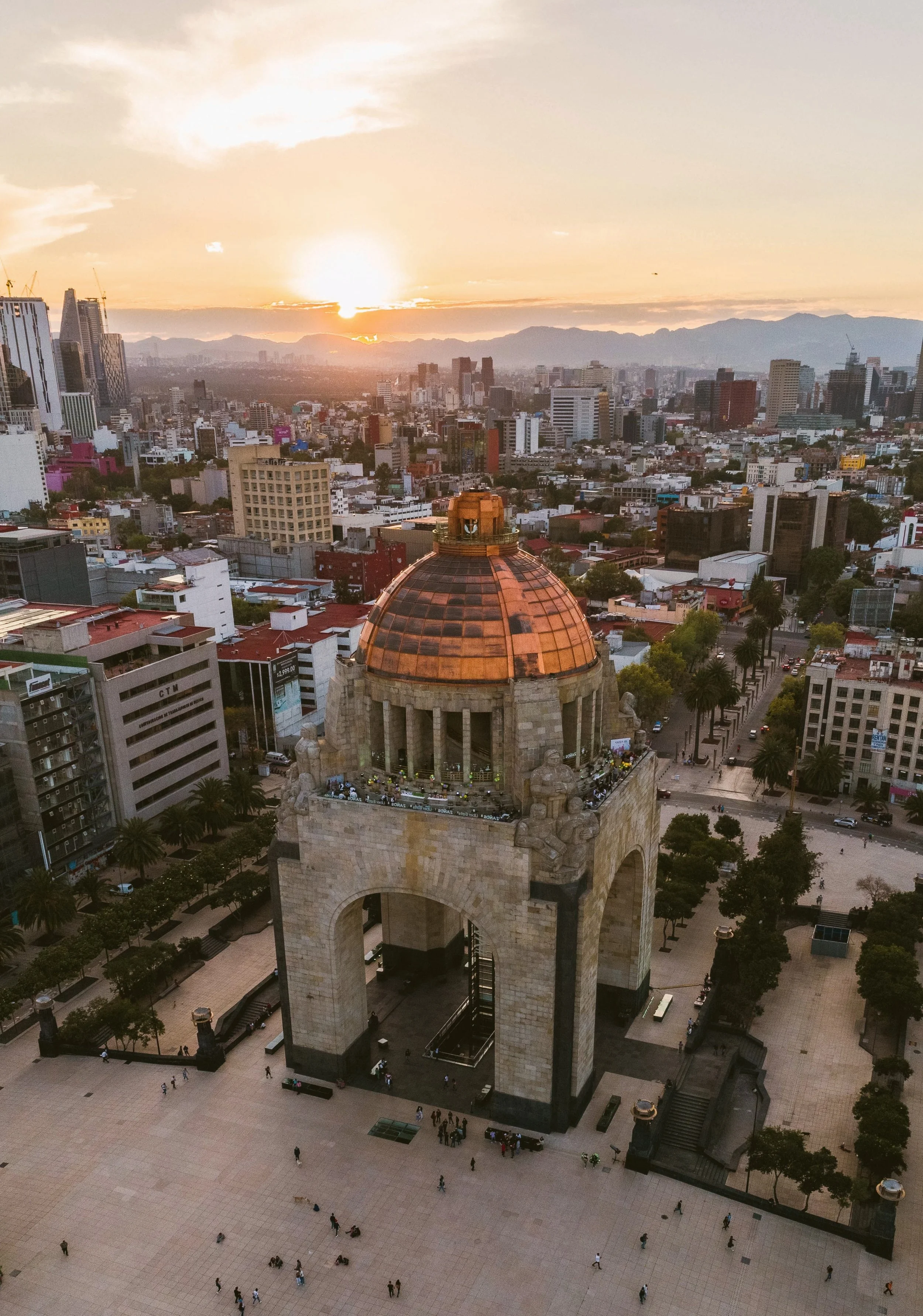Sunset over the Mexico City skyline with the dome of the Monumento a la Revolución in the foreground, Mexico City.