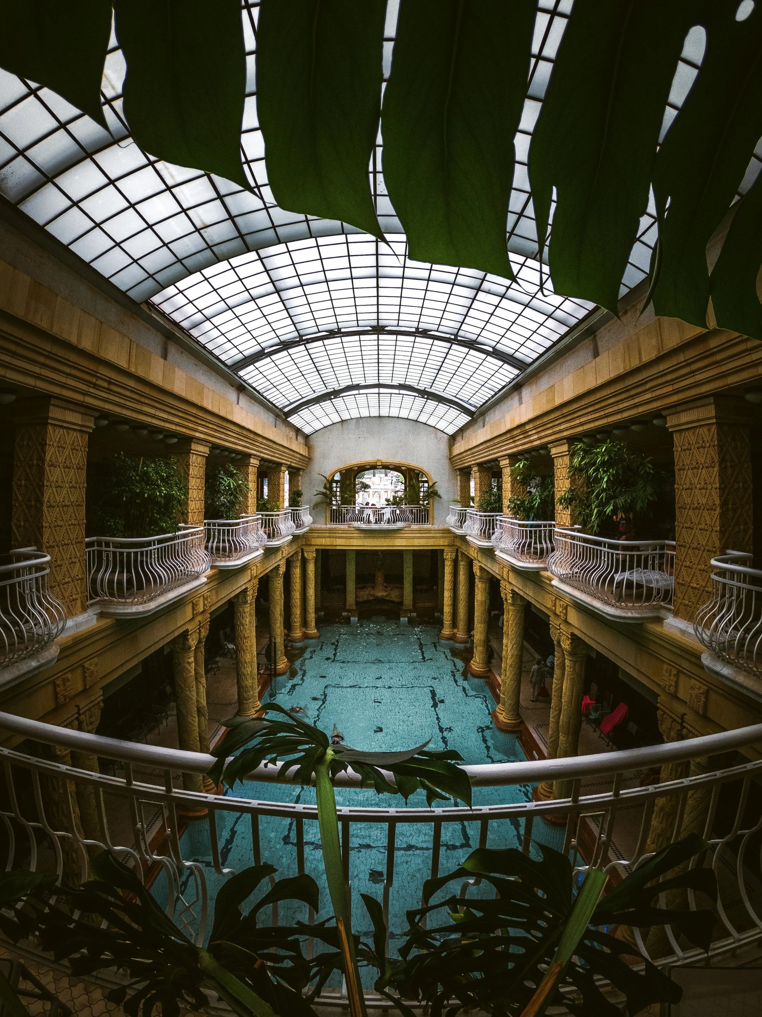 Glass-roofed hall with turquoise pool at Gellért Thermal Bath, Budapest