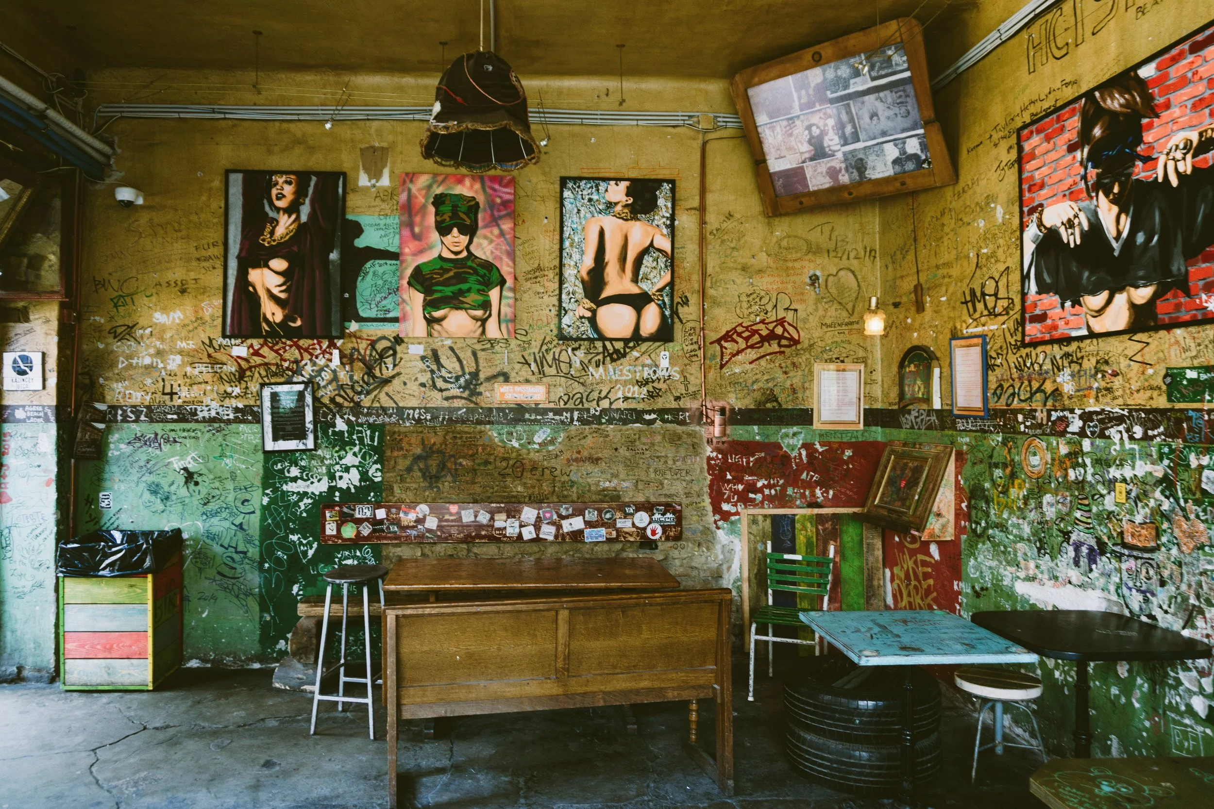 Eclectic ruin bar interior with mismatched furniture and wall art, Budapest