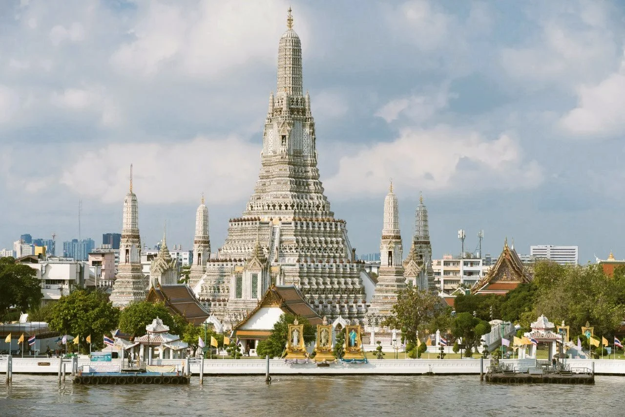 Wat Arun with its central prang and smaller towers seen from the Chao Phraya River, Bangkok.