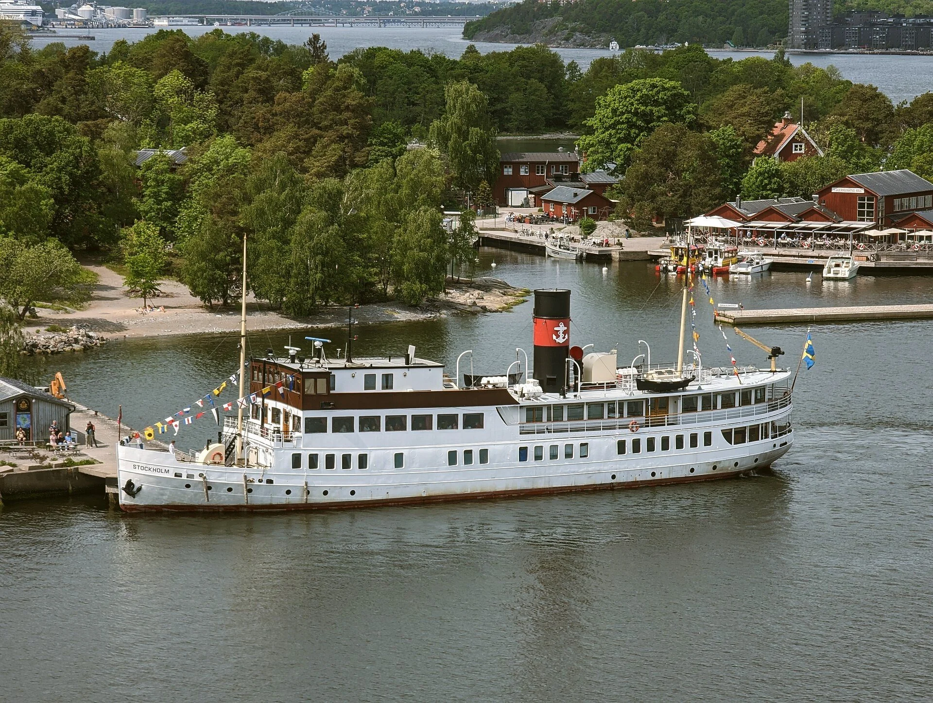 Vintage white steamboat with a red funnel sailing near Fjäderholmarna, Stockholm archipelago