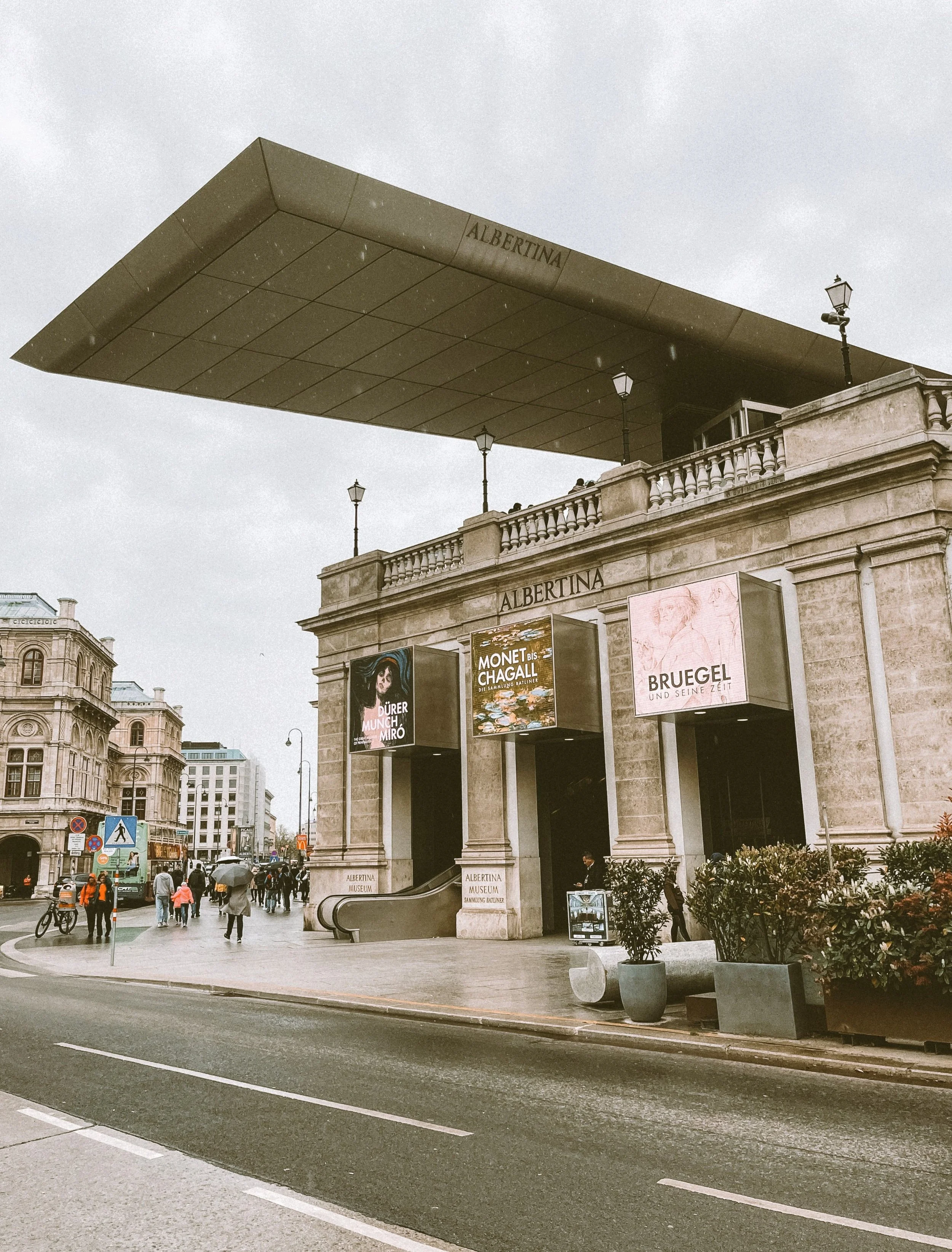 The Albertina Museum in Vienna, Austria, with its grand stone façade and banners advertising exhibitions.