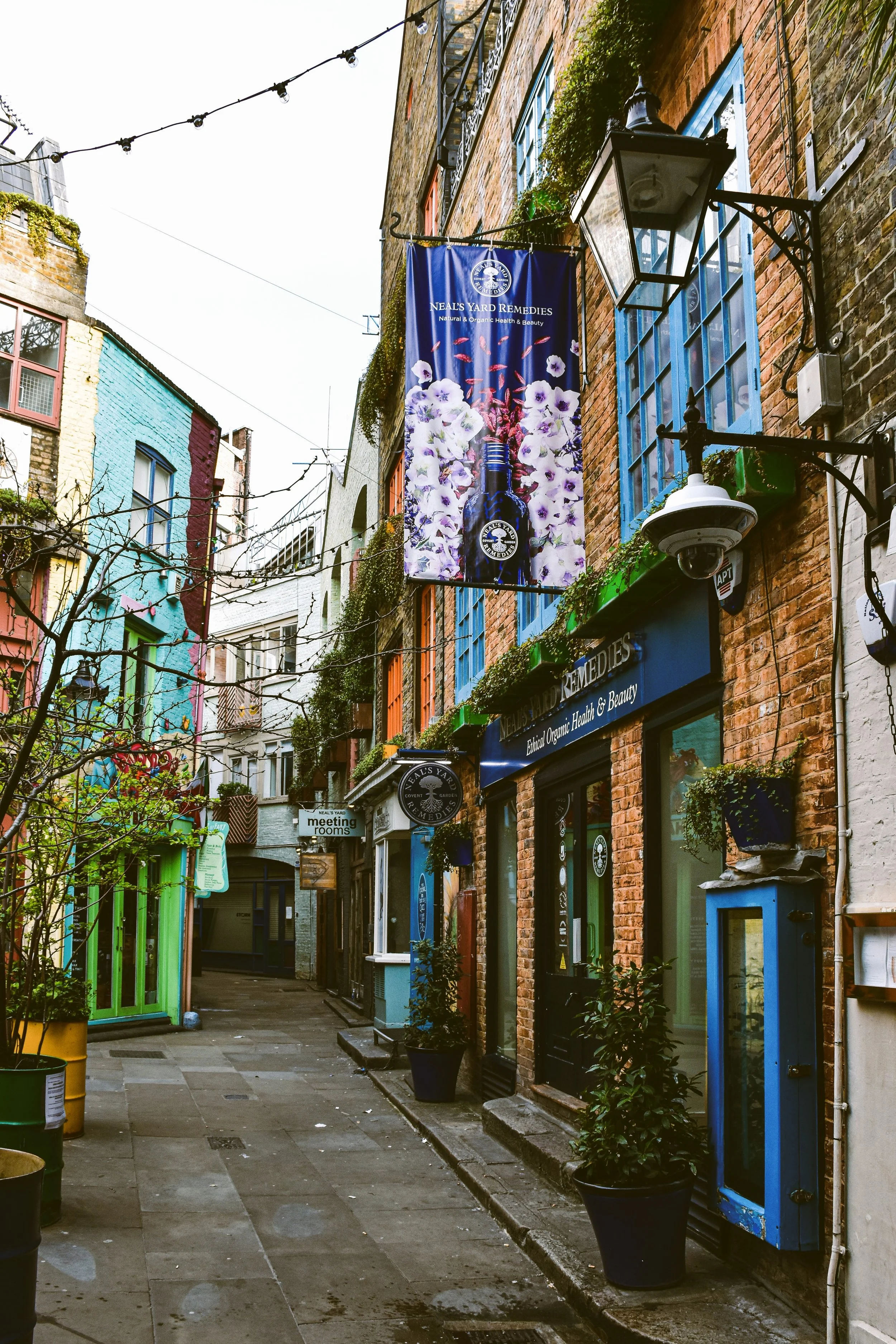 Colorful shopfronts and hanging string lights in Neal's Yard, Covent Garden, London.
