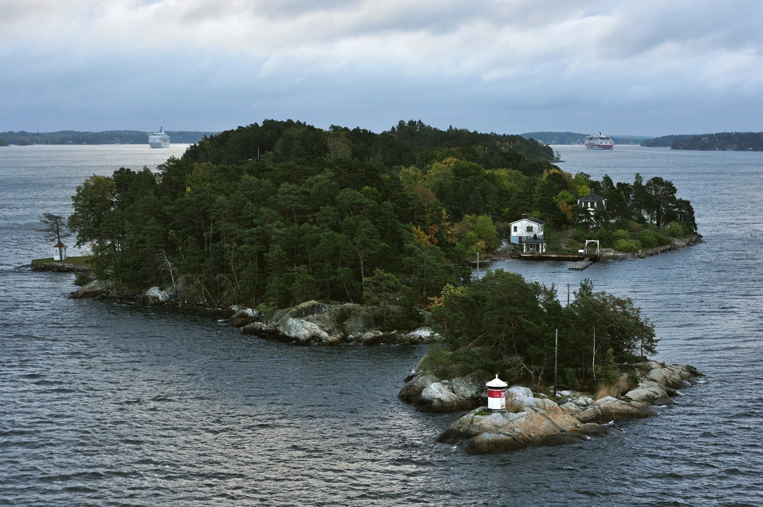 Small wooded islands with a red and white lighthouse in the Stockholm archipelago