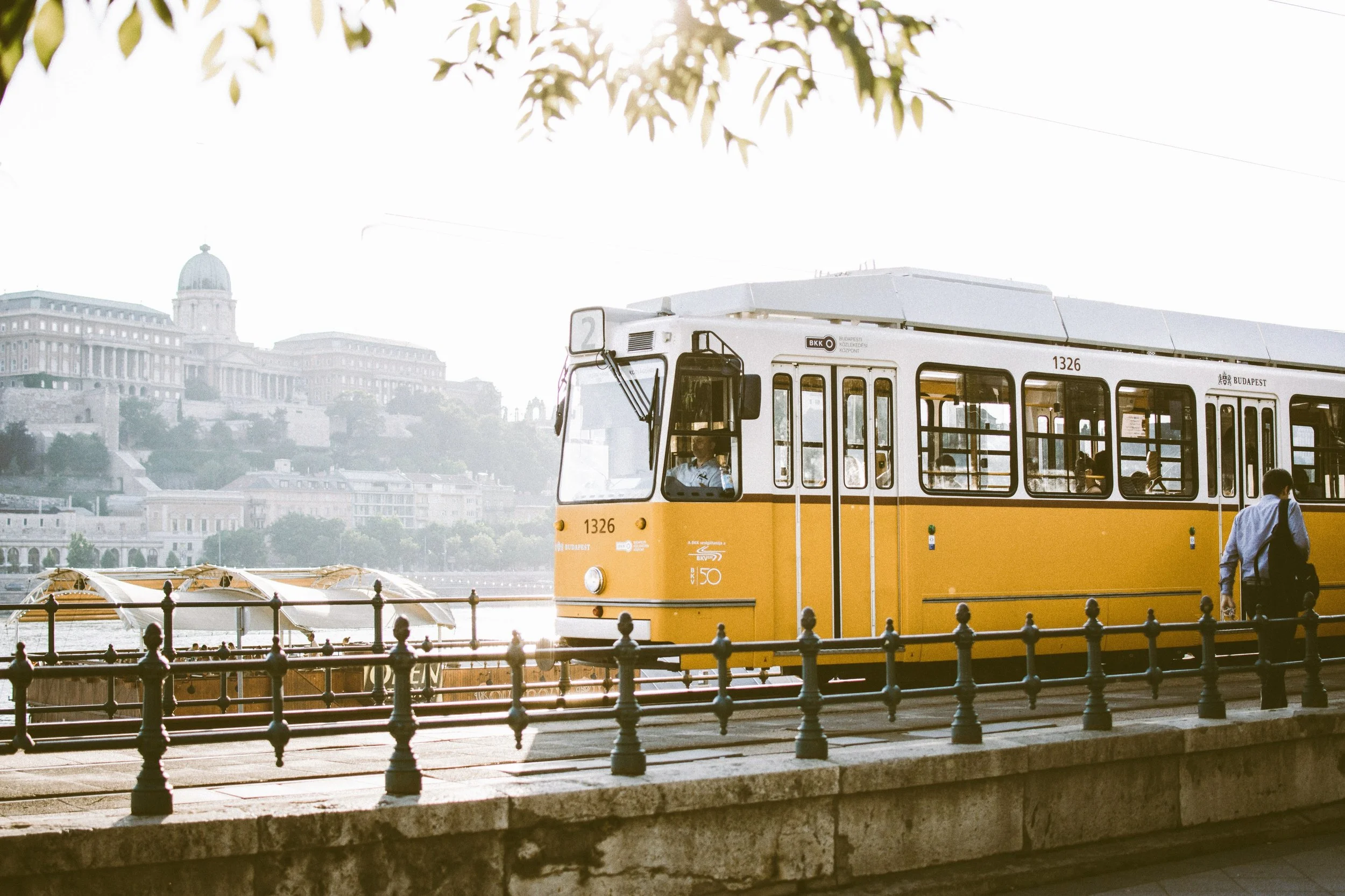 Yellow tram 2 along the Danube embankment with Buda Castle behind, Budapest