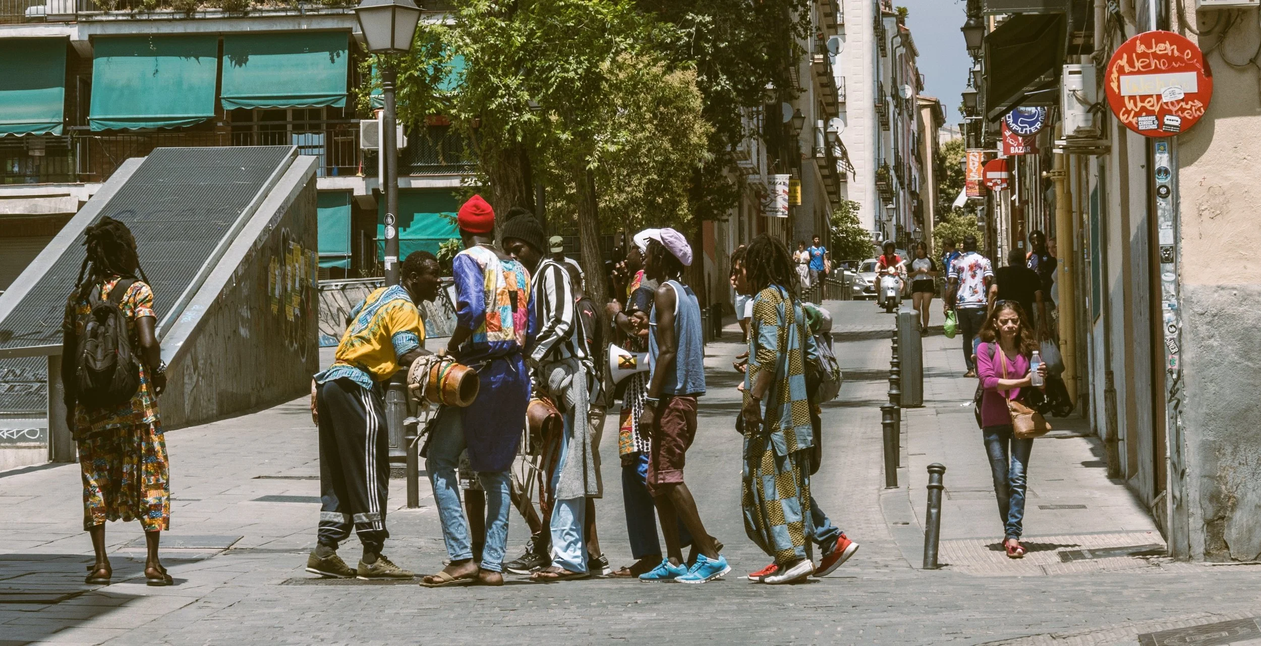 Group of people with drums gathered on a sunny street in Lavapiés, Madrid