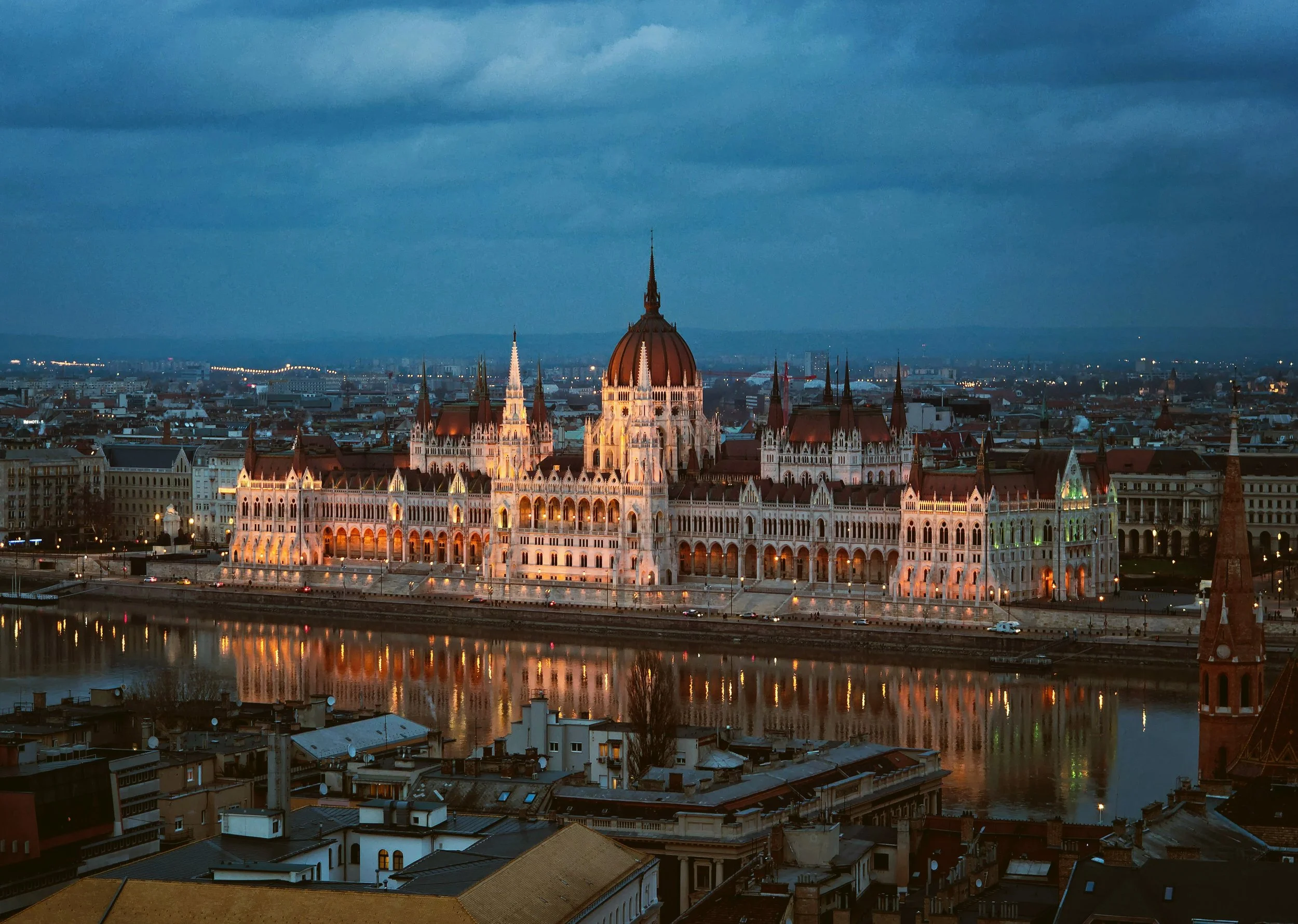 Hungarian Parliament Building lit at night under a stormy sky, Budapest