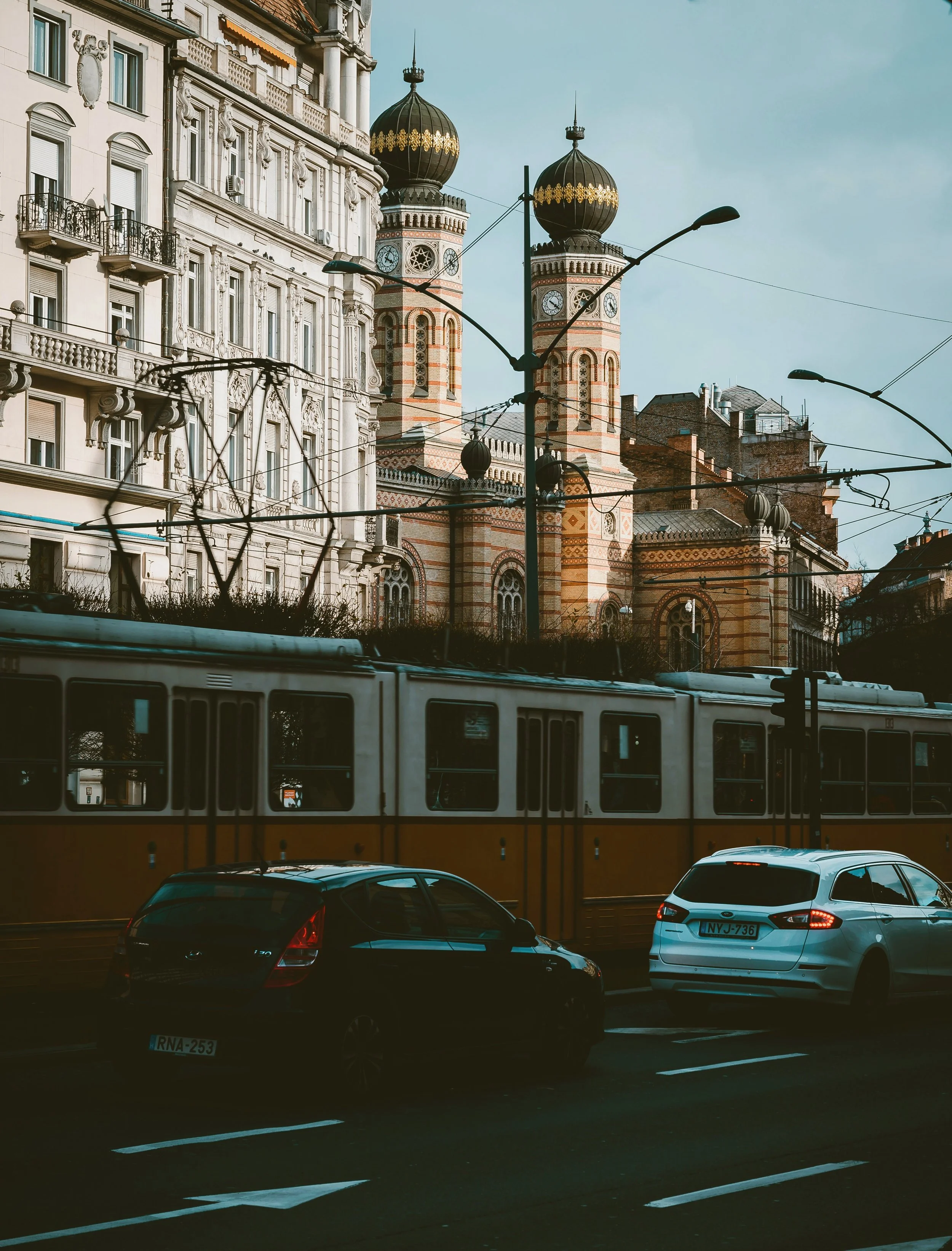 Yellow tram passing the Dohány Street Synagogue in Budapest