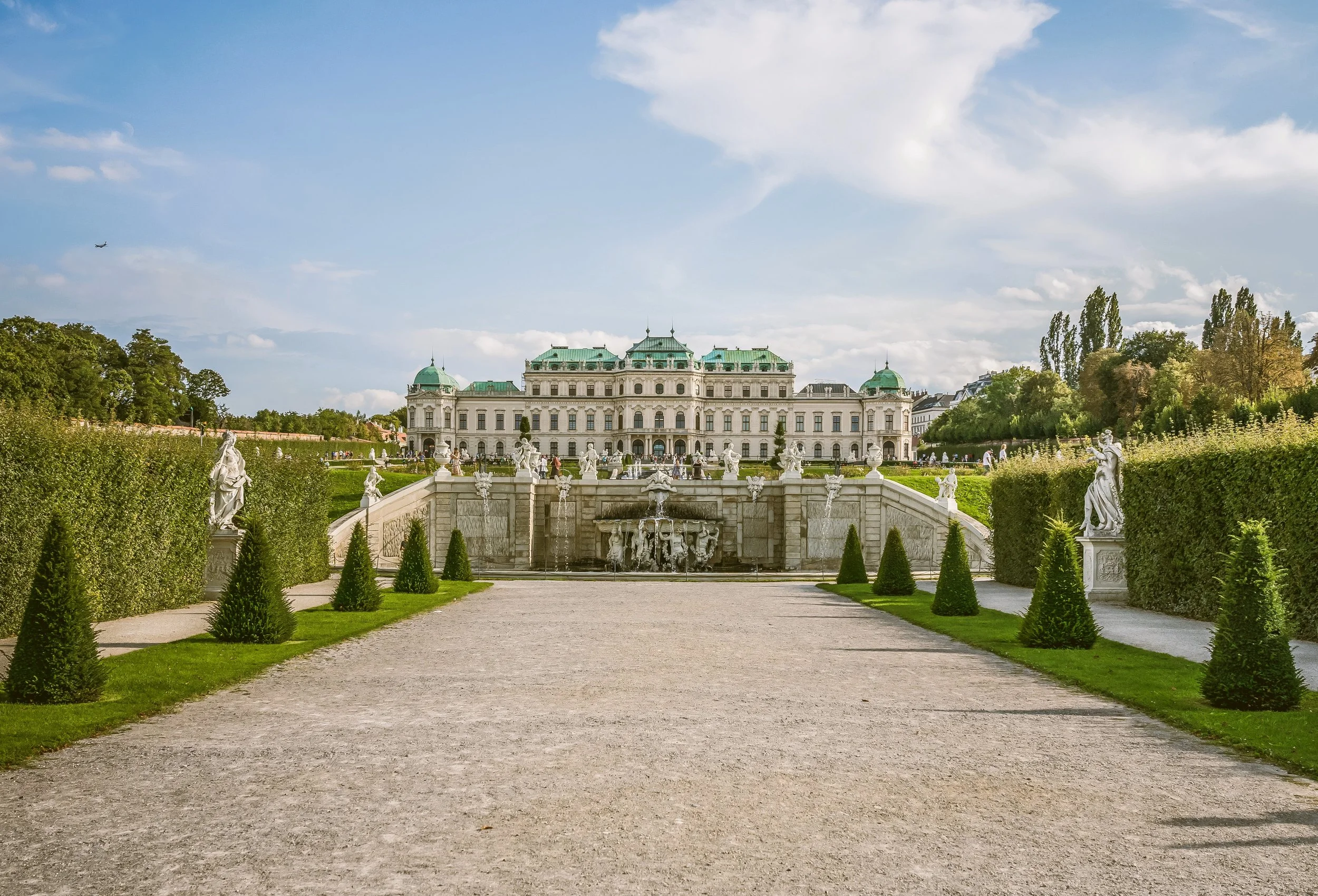 Upper Belvedere Palace at the end of a gravel path lined with manicured hedges and gardens, Vienna.