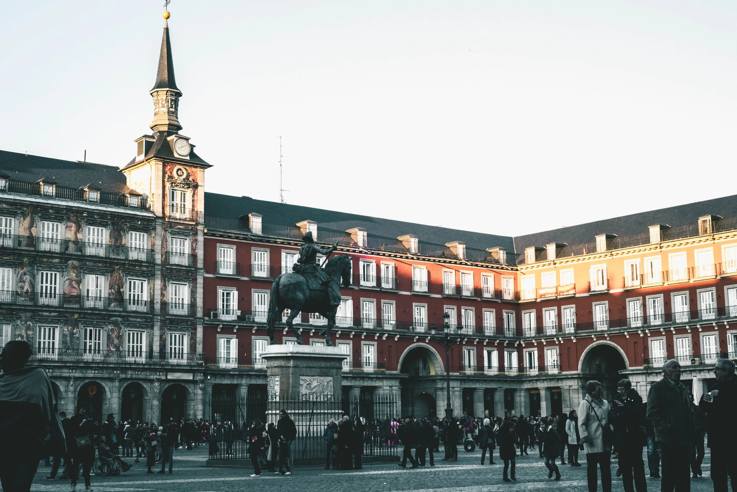 Equestrian statue of Philip III in front of the red arcaded facade of Plaza Mayor, Madrid