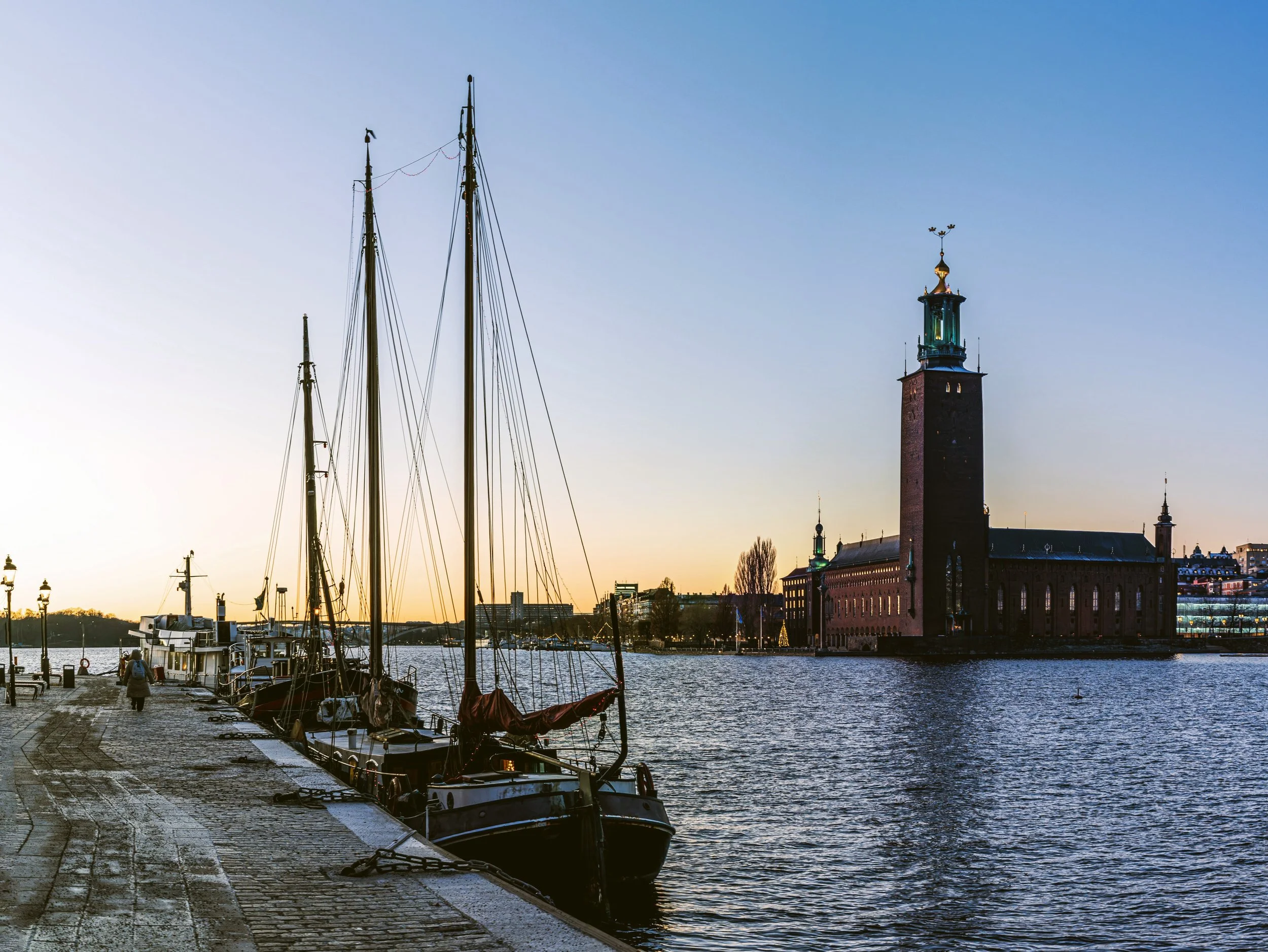 Stockholm City Hall across the water at dusk with a moored sailboat