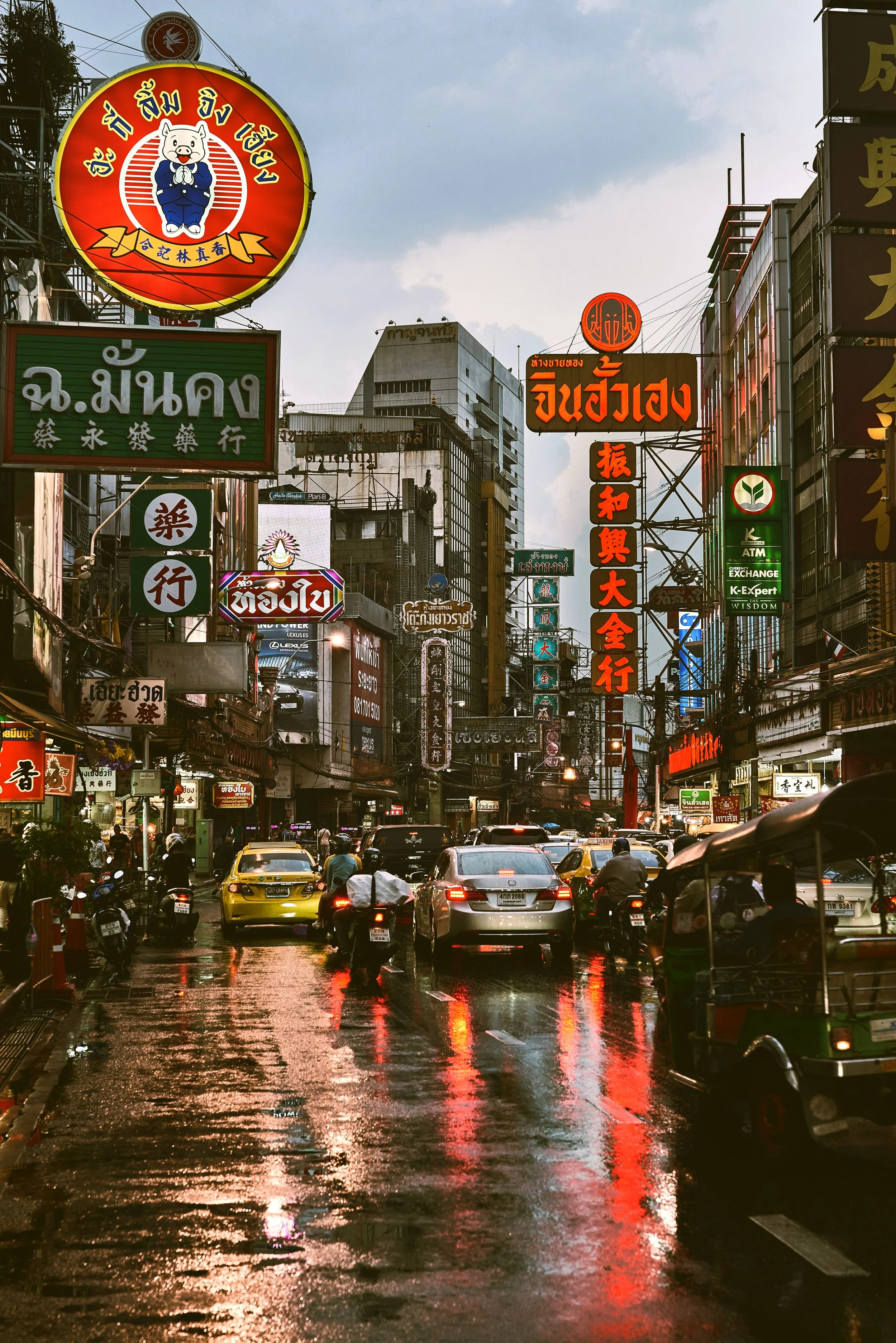 Wet street in the evening with neon signs and reflections on the pavement, Yaowarat, Chinatown, Bangkok.