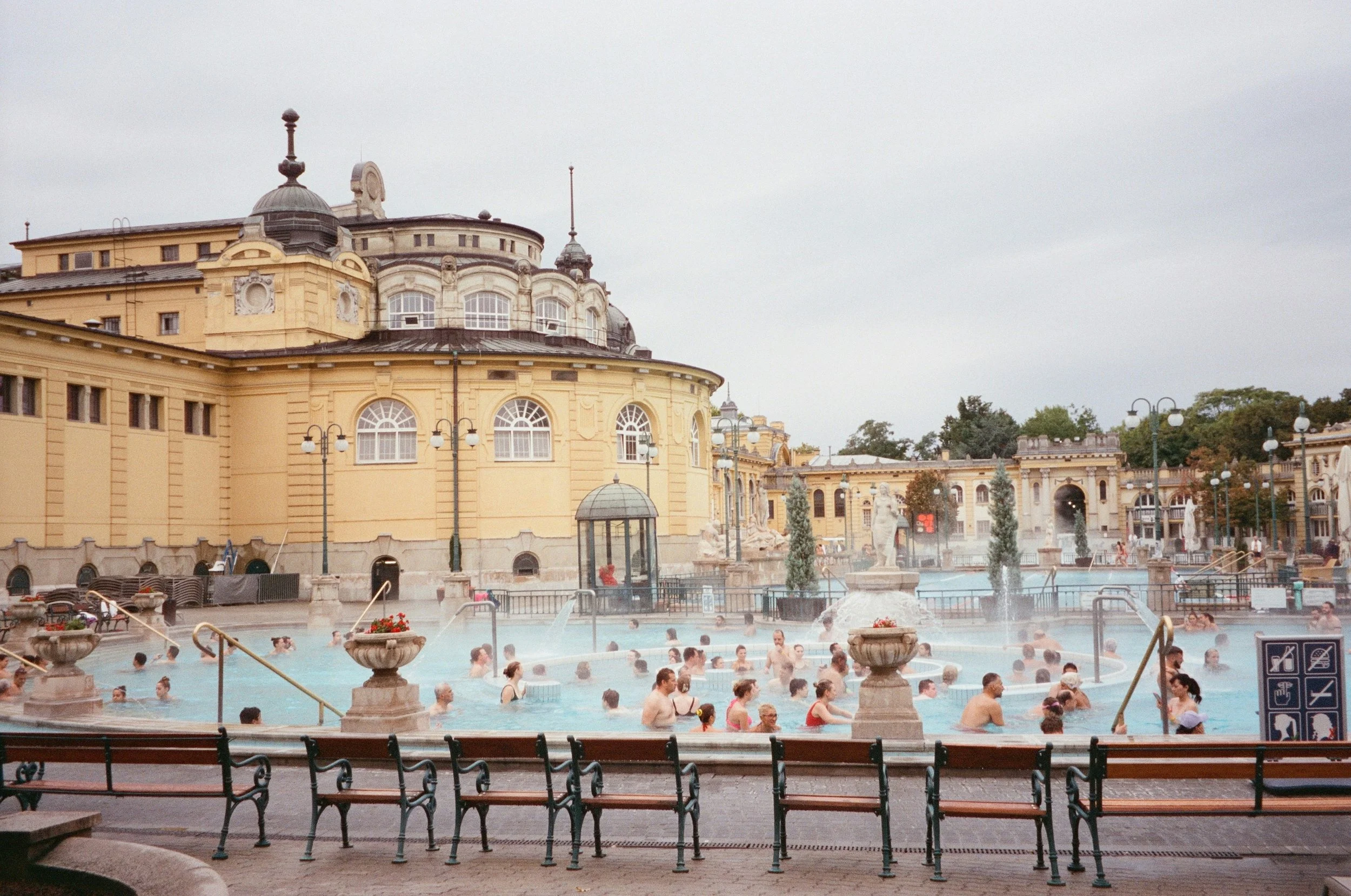 Bathers at Széchenyi Thermal Bath's outdoor pool, yellow building behind, Budapest