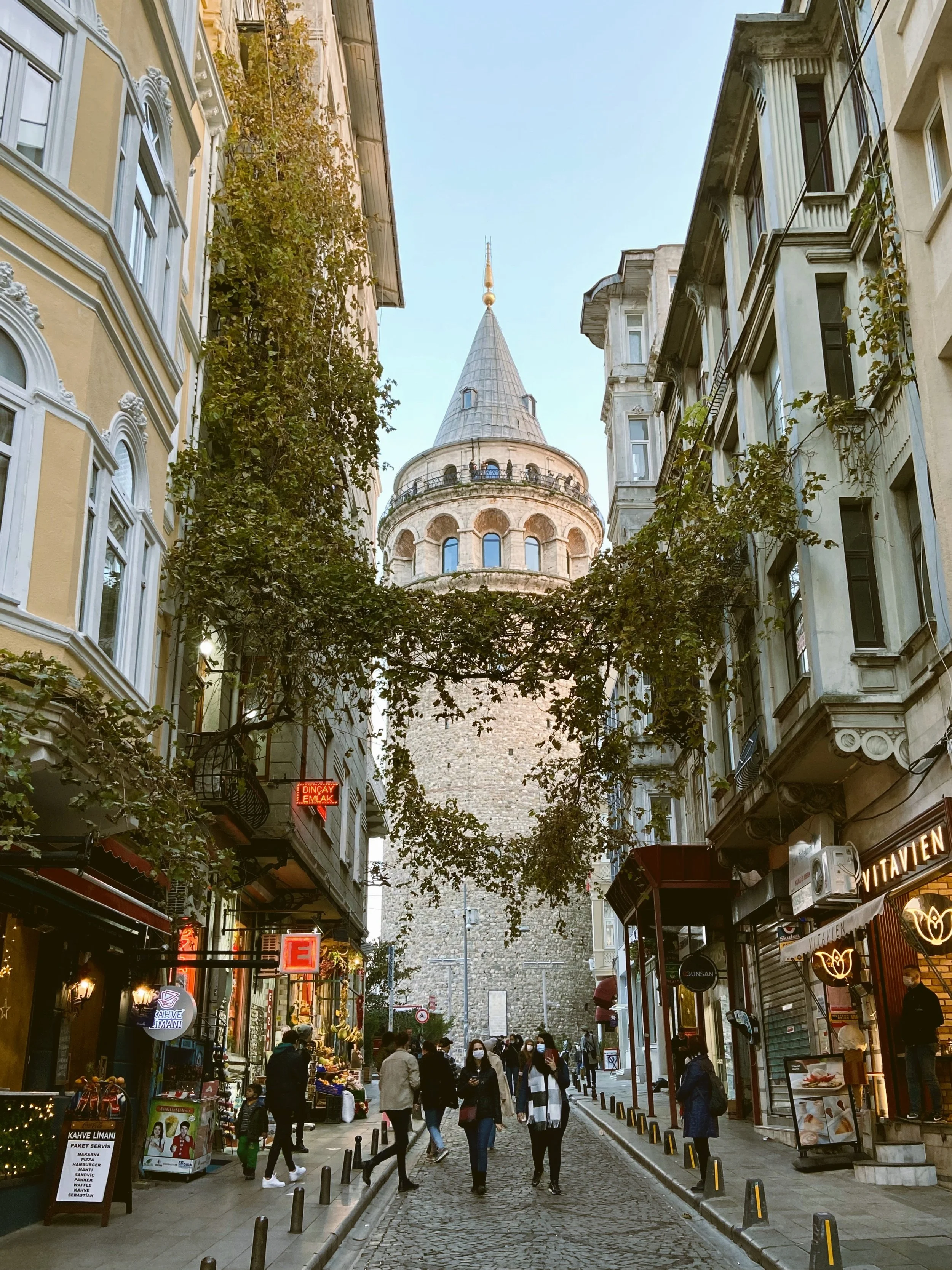 Galata Tower at the end of a narrow street lined with historic buildings, Istanbul.