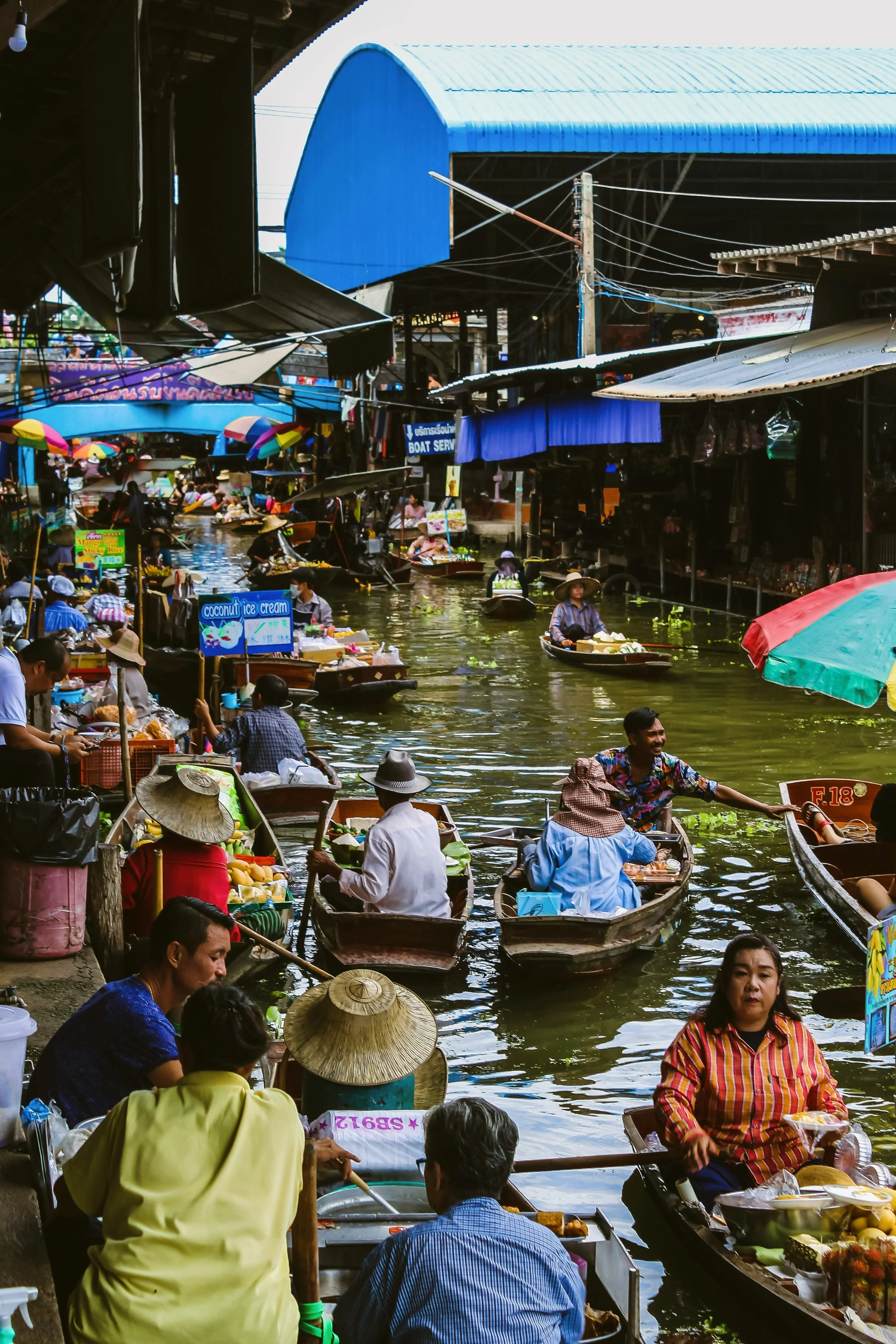 Vendors in small boats crowded together at a floating market, Bangkok.