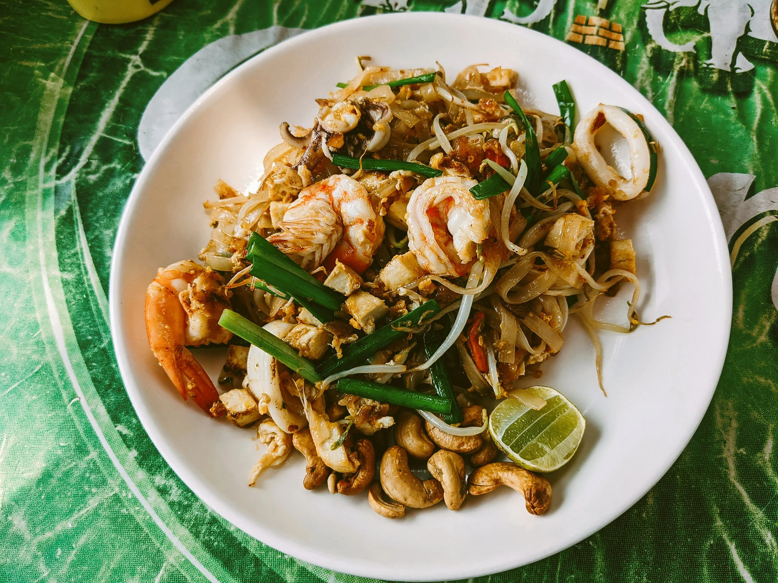 Plate of pad thai with shrimp, mussels and lime on a banana leaf, Bangkok.