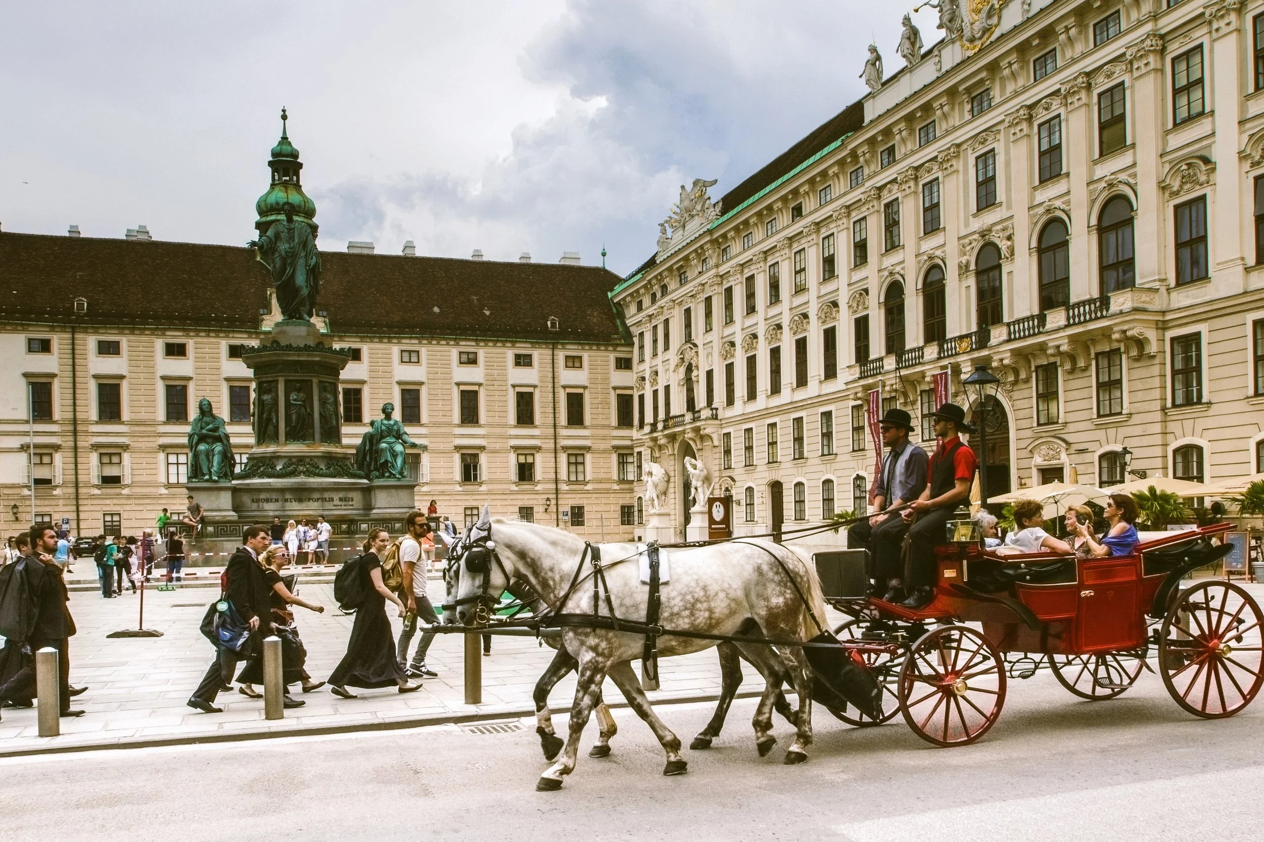 Horse-drawn carriage crossing a palace courtyard, Hofburg, Vienna.