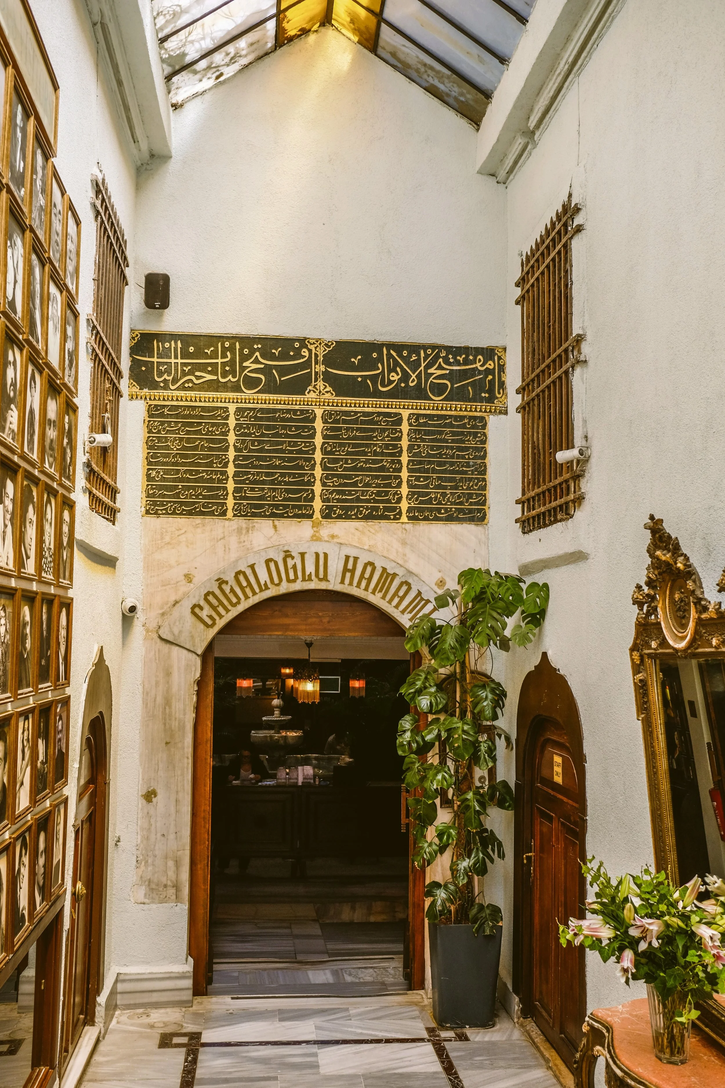 Stone archway entrance with hanging lanterns inside a historic hamam, Istanbul.