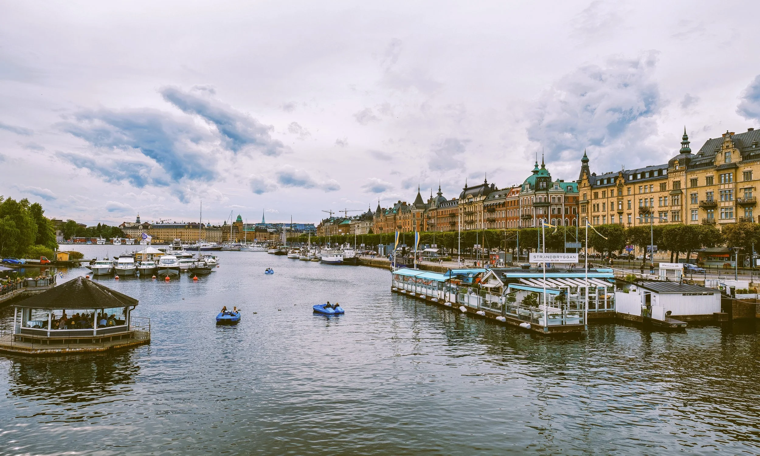 Historic buildings and moored boats along Strandvägen seen from Djurgården bridge, Stockholm