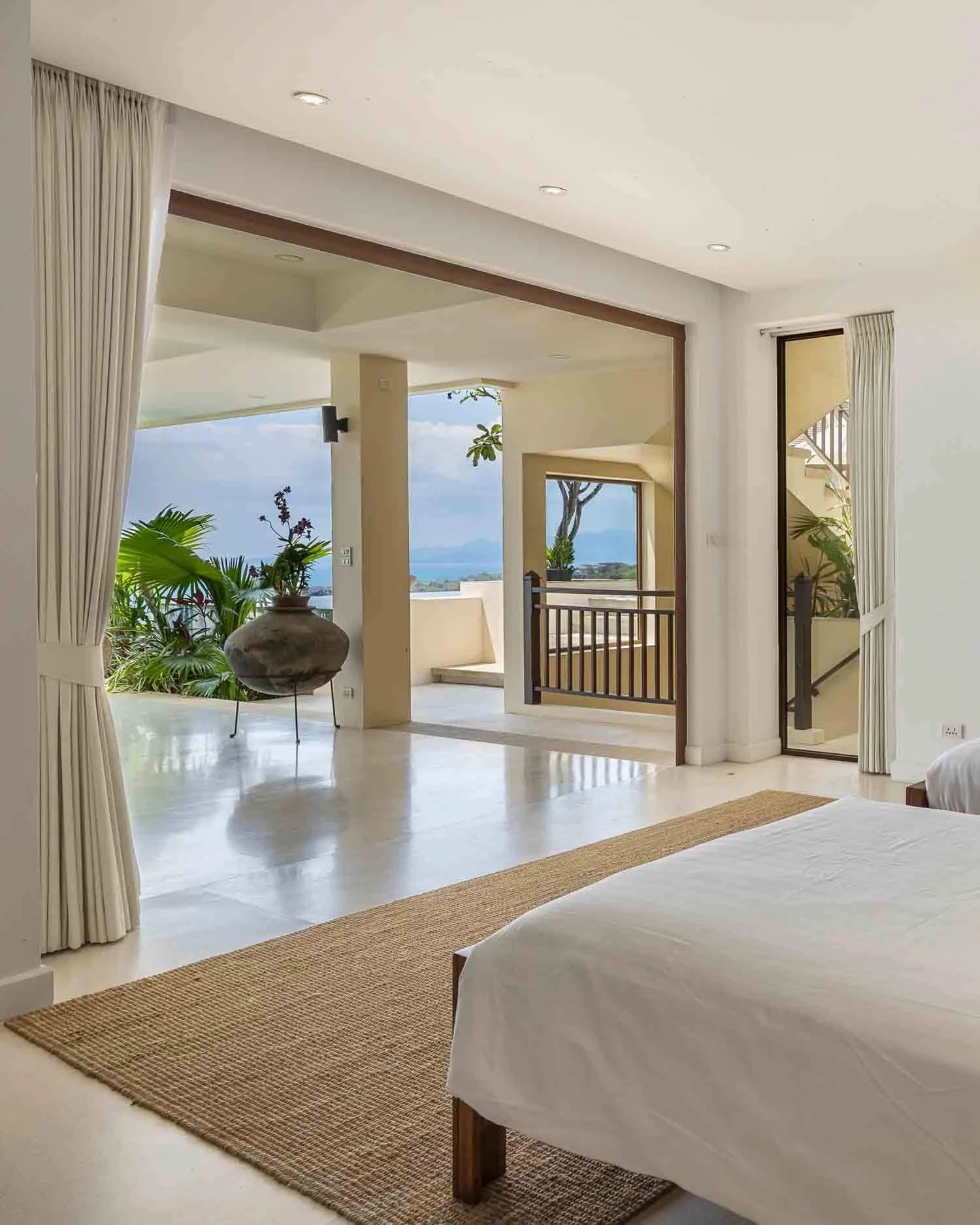 Interior view from a bedroom suite looking out onto the covered outdoor terrace at Saensook eco villa in Koh Samui