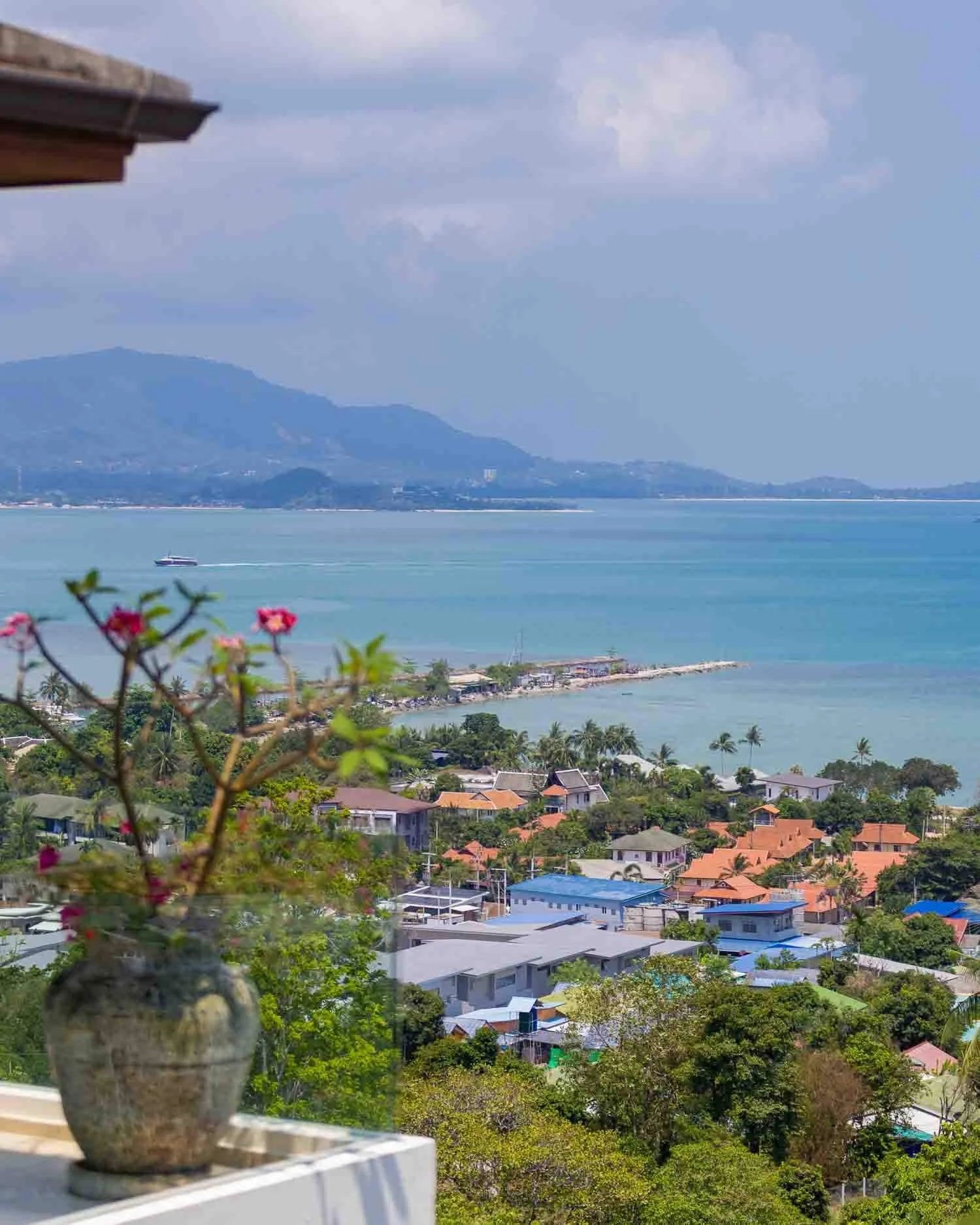 High-angle view of the local coastal neighborhood, lush greenery, and turquoise sea near Choeng Mon Beach from Saensook villa
