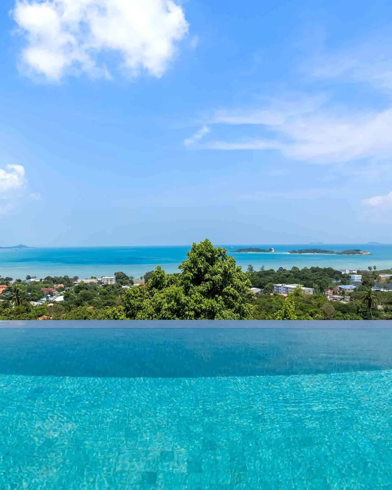 Stunning view looking across the infinity pool toward the blue ocean and coastal landscape near Choeng Mon Beach from Saensook eco villa in Koh Samui