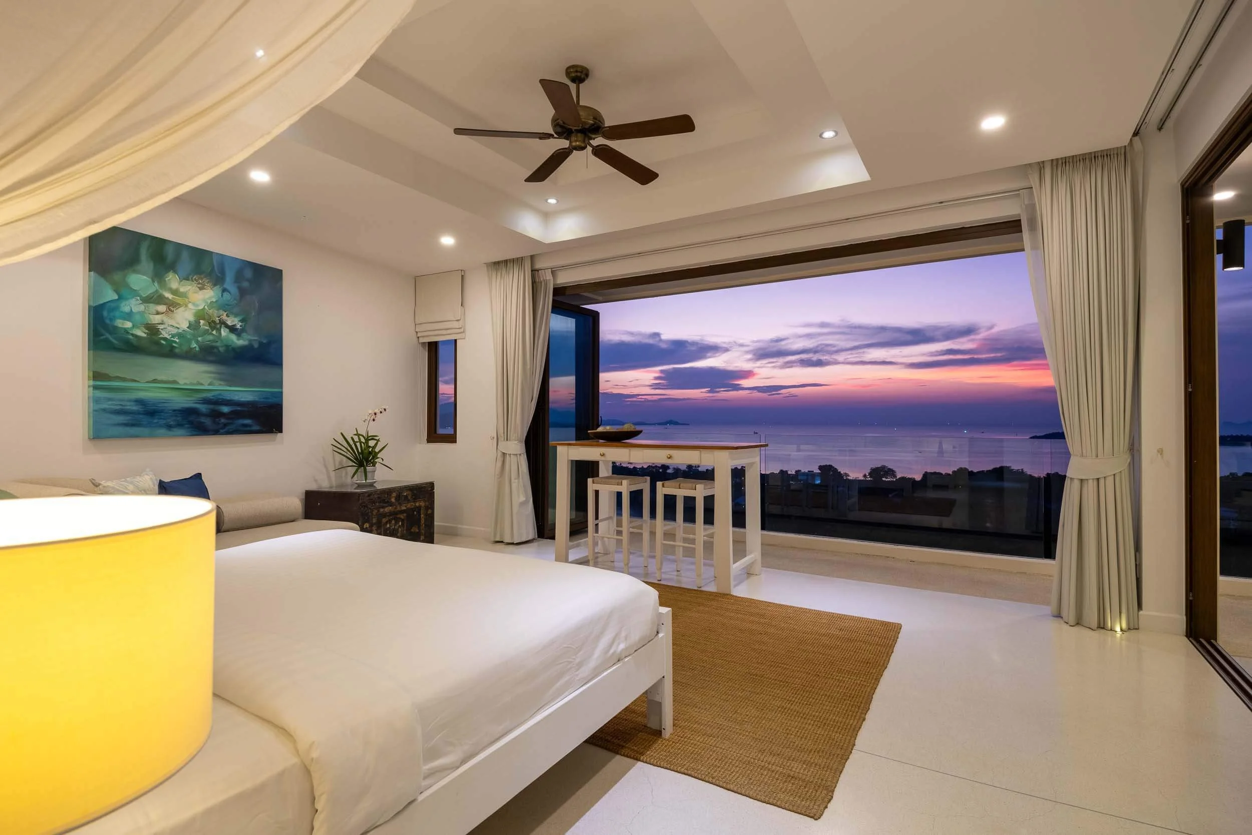 Stunning evening sunset view framed by the open sliding glass doors of the Sundown Suite bedroom at Saensook eco villa, Koh Samui