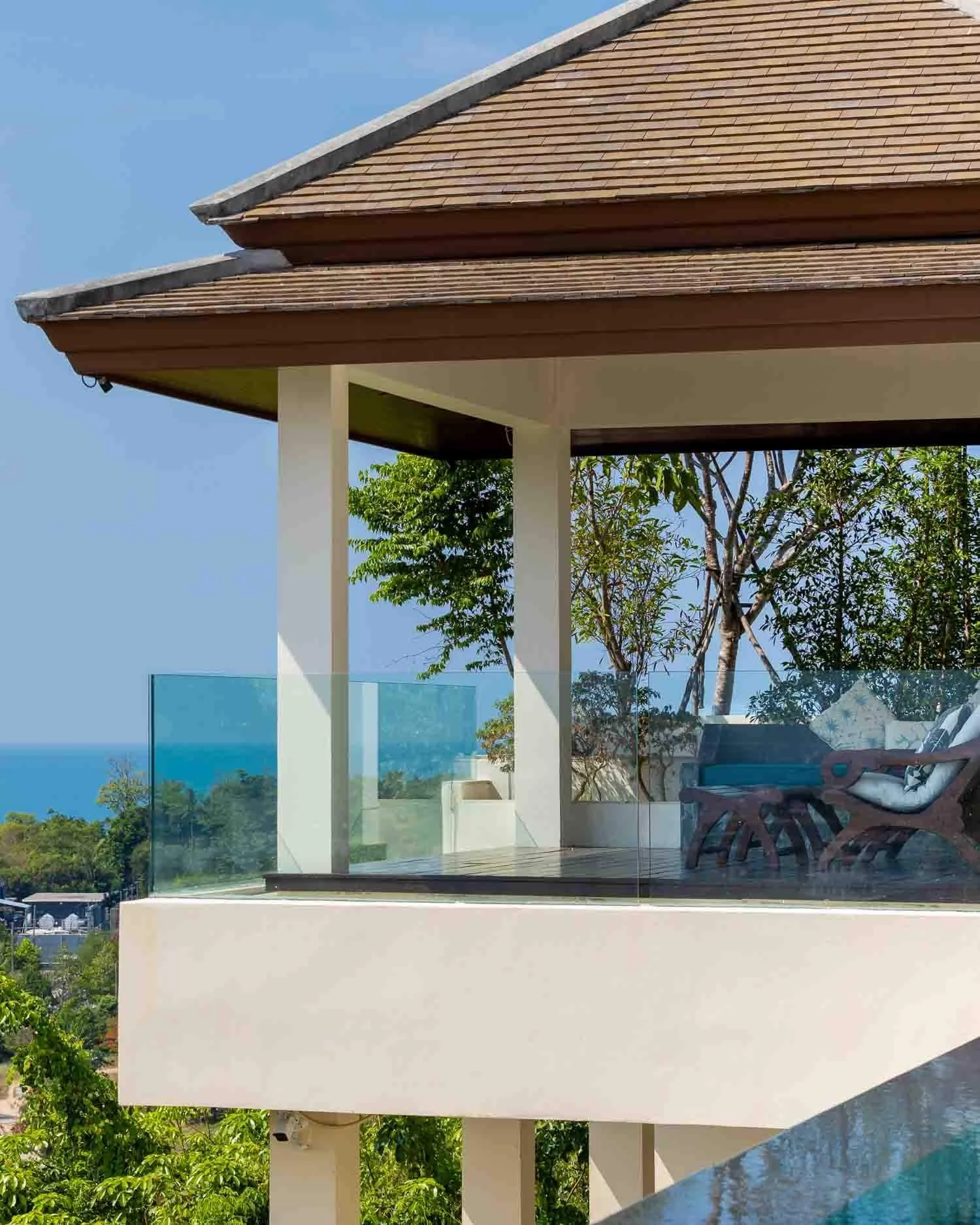 Covered architectural pavilion and glass-balustrade terrace overlooking the stunning coastal views at Saensook villa