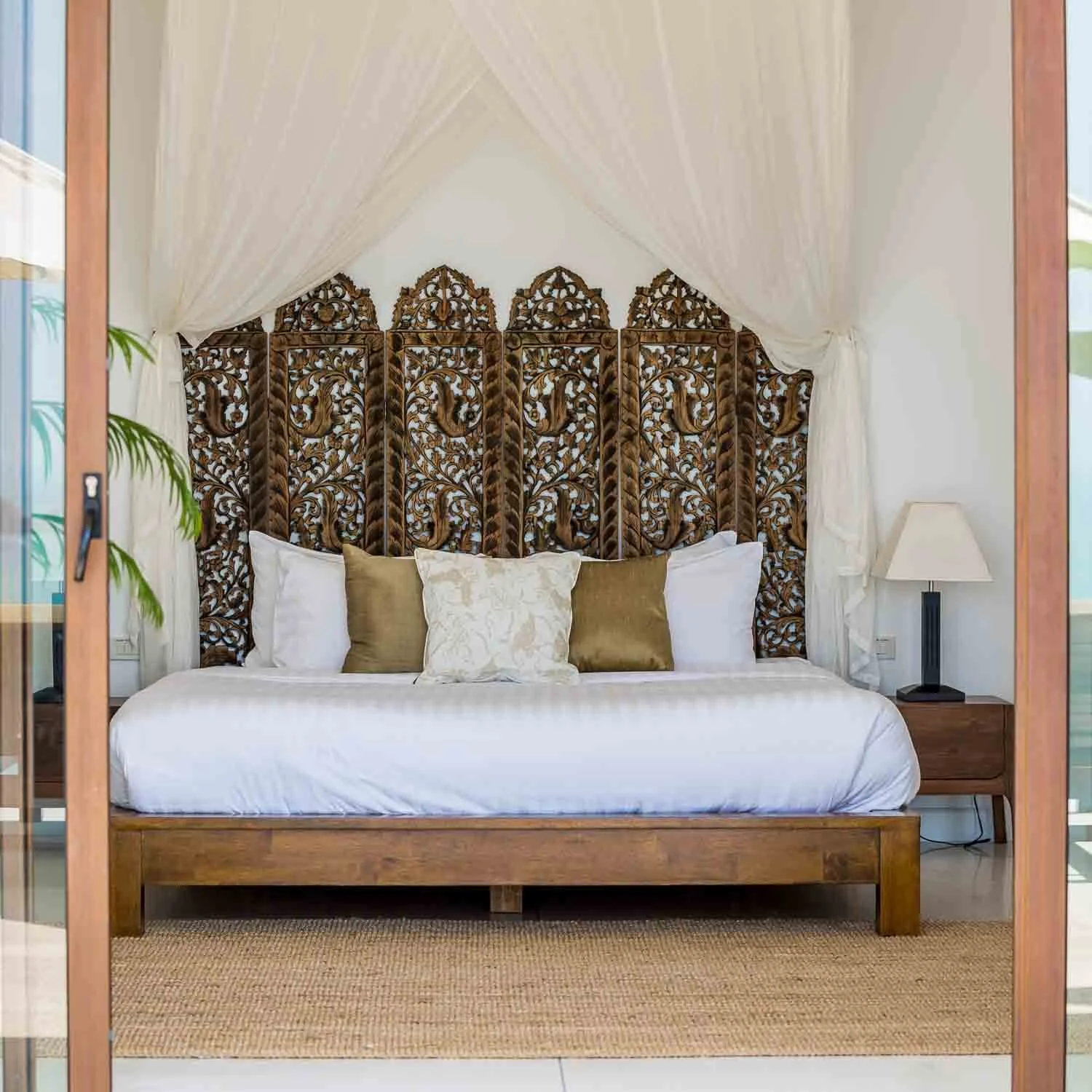 Bedroom suites at Saensook Villa Koh Samui feature a king-size bed, crisp white linens, direct pool access, and floor-to-ceiling glass sliding doors.
