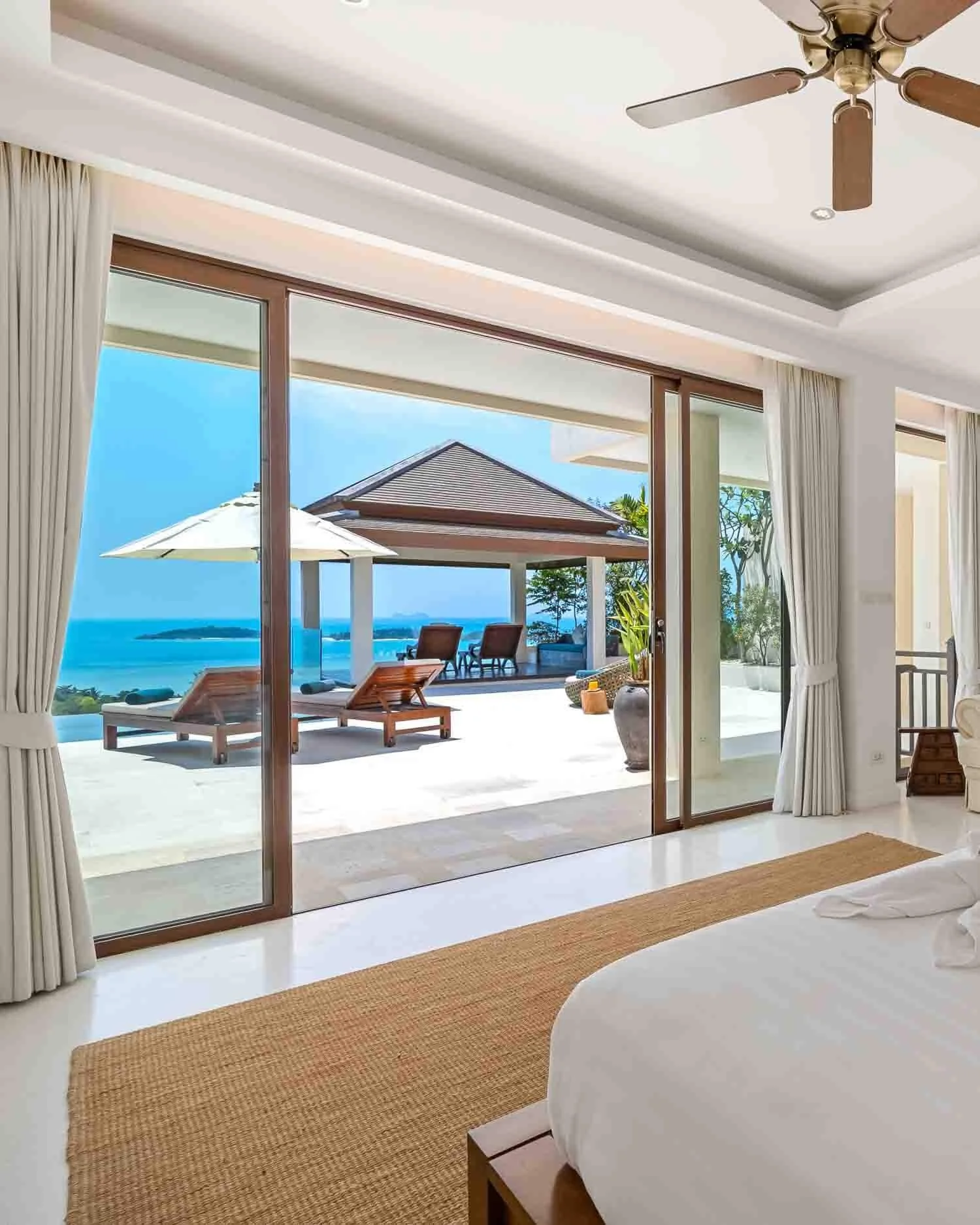 Luxury bedroom at Saensook villa opening directly onto the pool terrace with breathtaking views