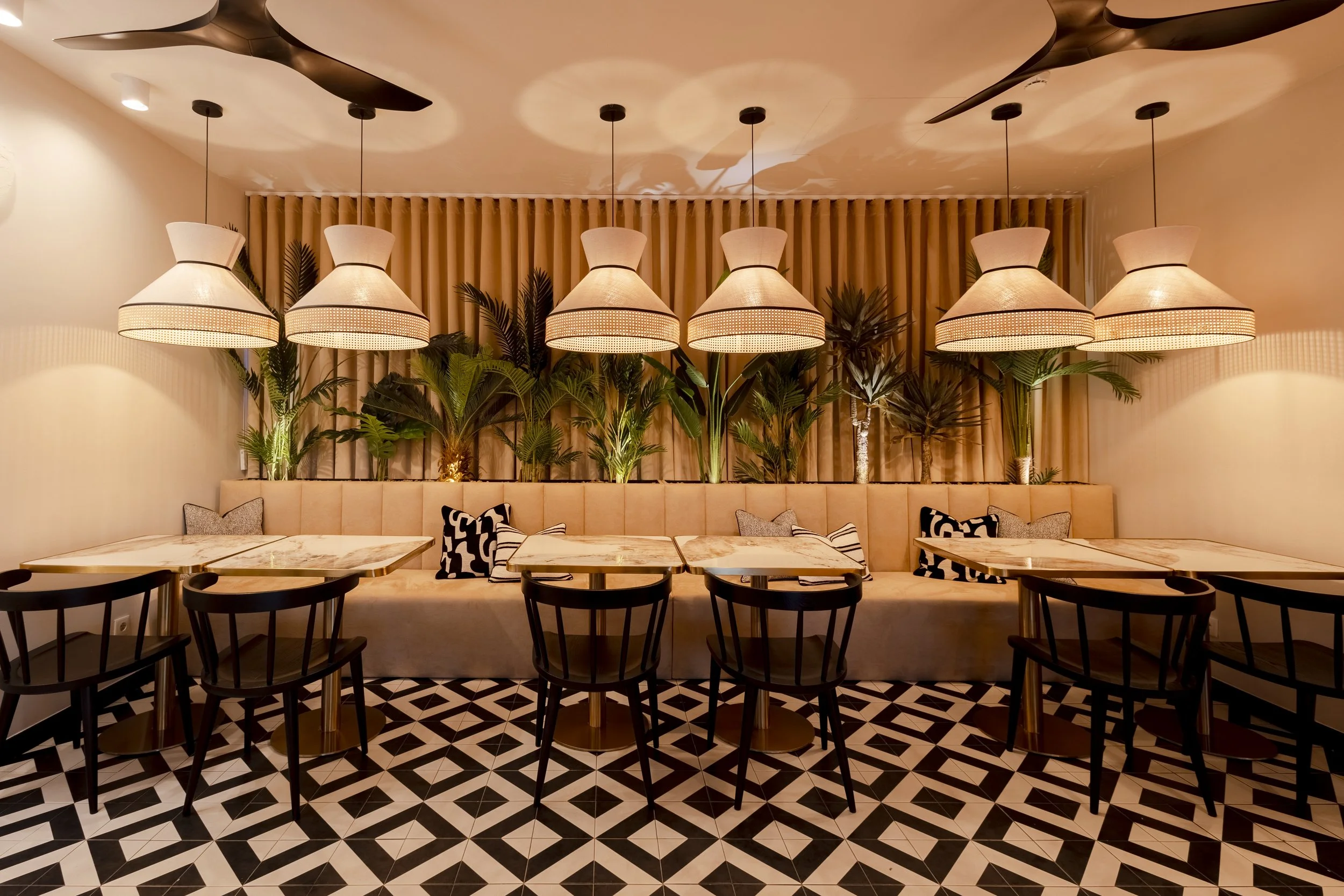 Interior do Giga Brunch com iluminação suspensa, plantas e zona de refeições, perto do Porto