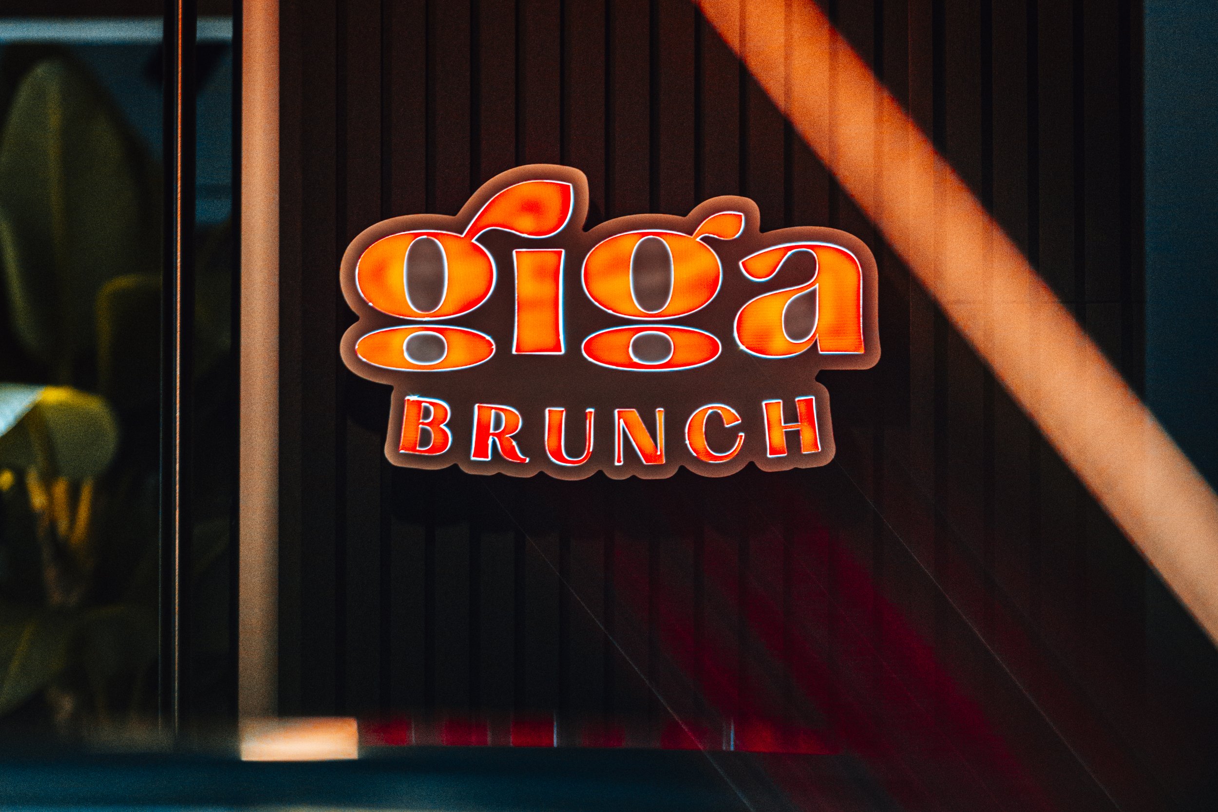 Logótipo Giga Brunch em néon no interior do espaço, perto do Porto
