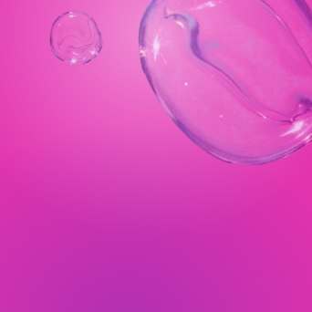 Close-up of soap bubbles against a pink background.
