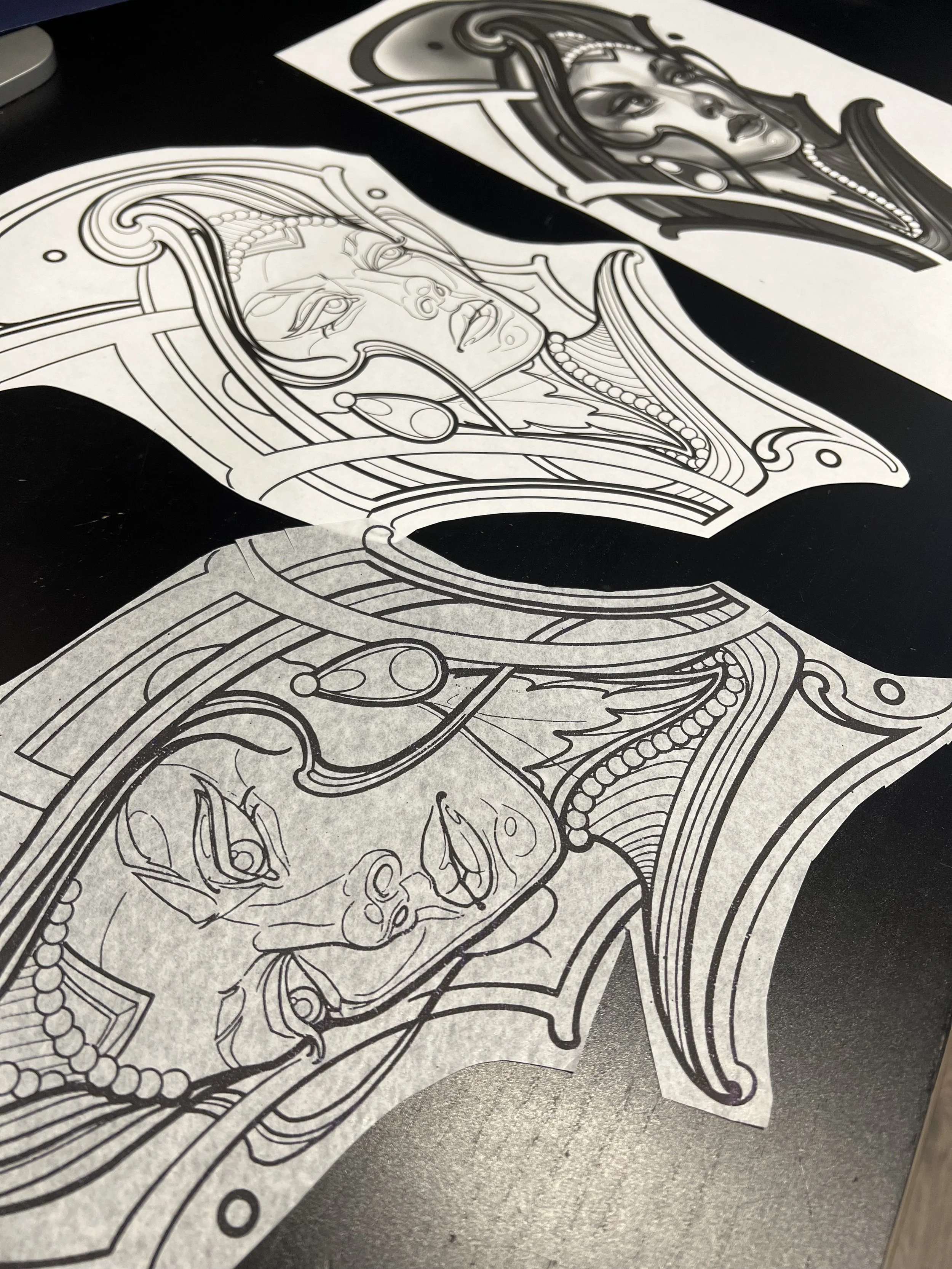 Black and white line art sketches of a woman's portrait and decorative designs on paper.