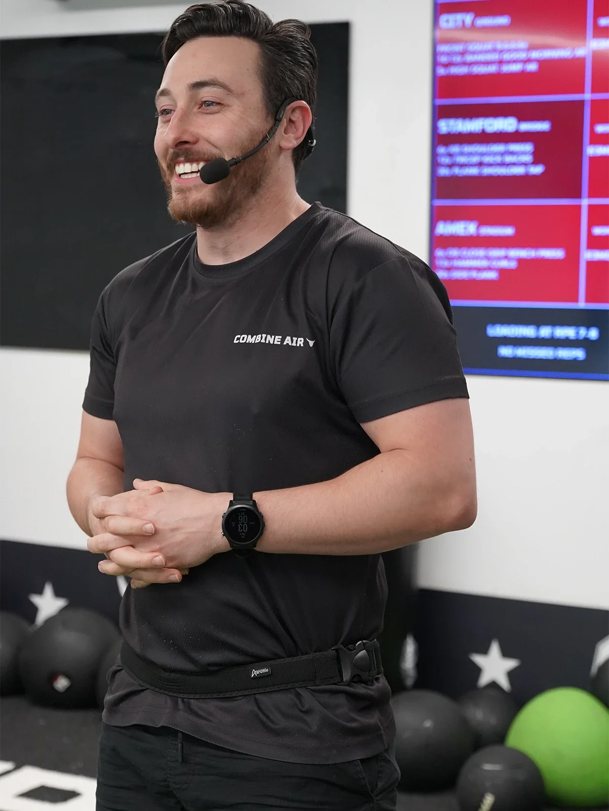 A man smiling and wearing a black sports t-shirt with