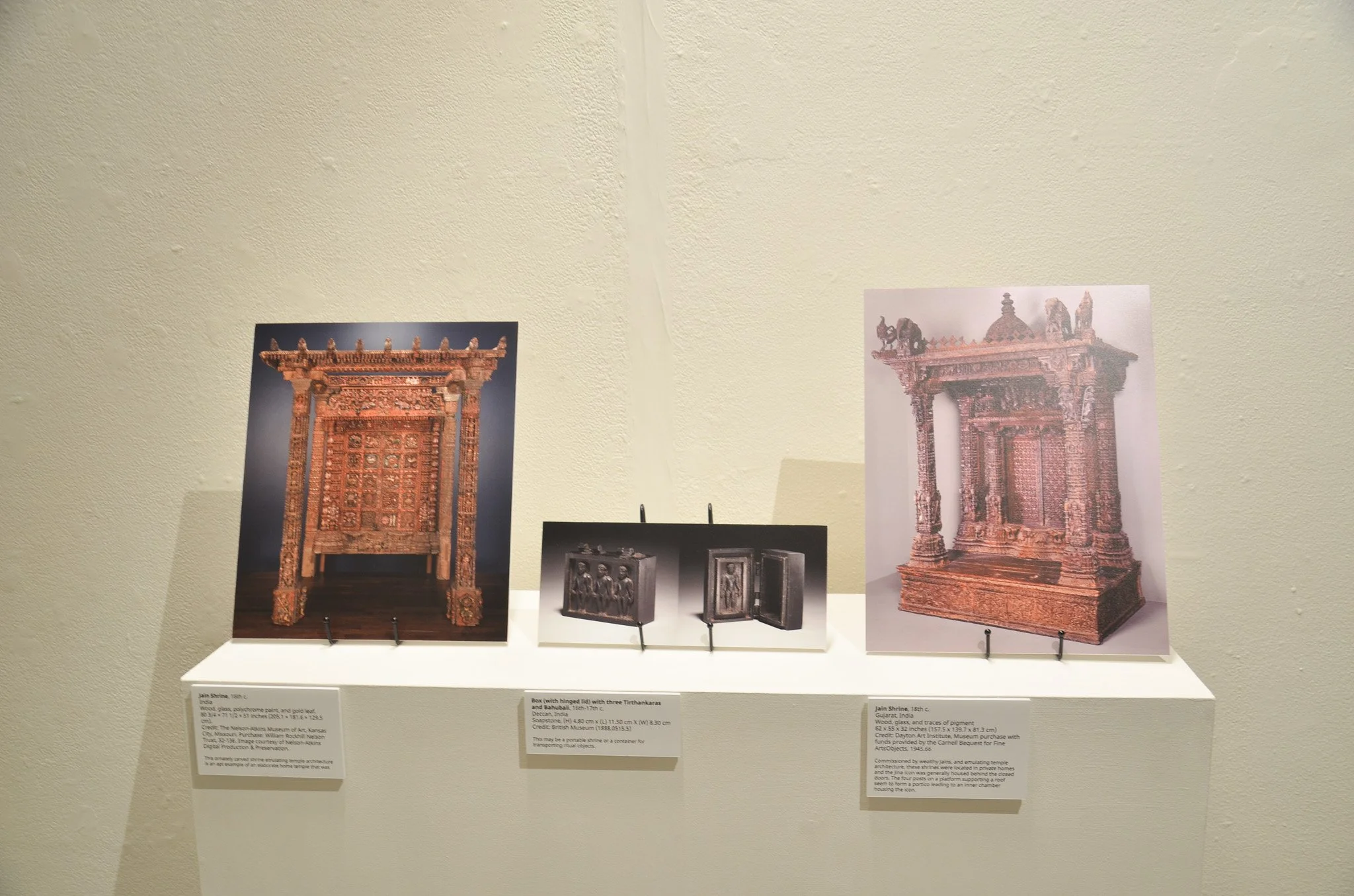 Photo of two ancient Indian gateways from Jain shrines, one on the left and one on the right, displayed in a museum exhibit with informational plaques below.