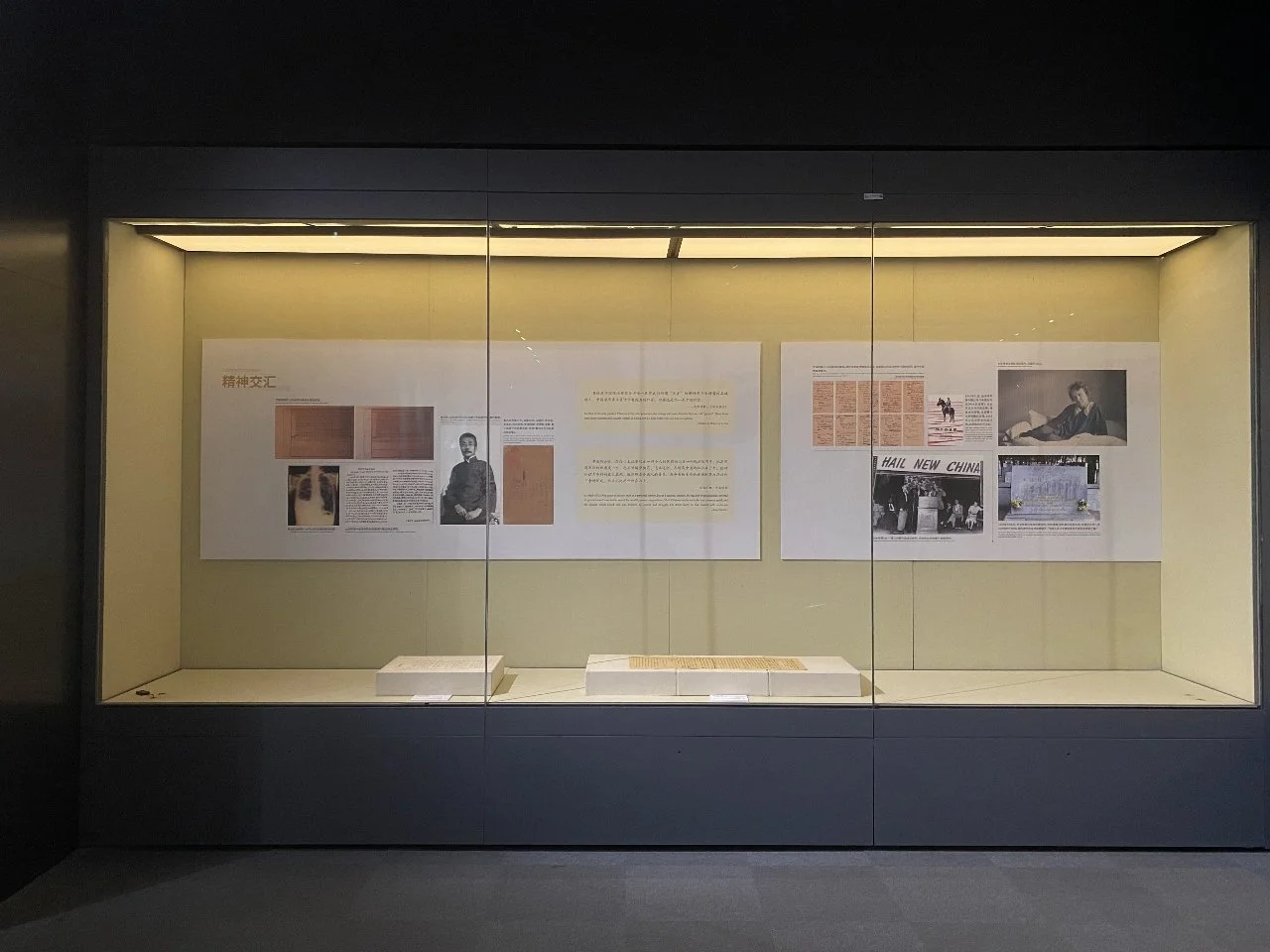 Museum display case with historical posters, photographs, and documents related to Chinese history and cultural exchange.