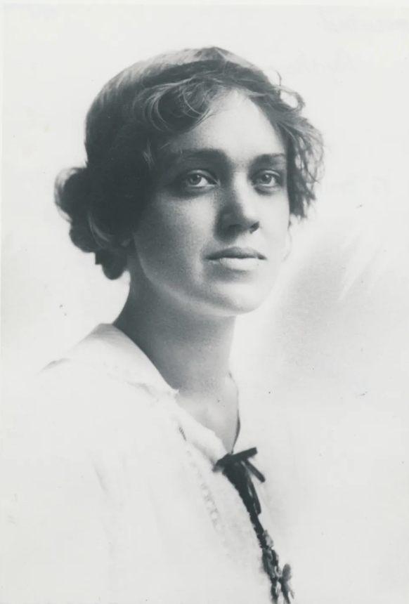 Black and white portrait of a young woman with short, wavy hair, looking directly at the camera with a neutral expression.