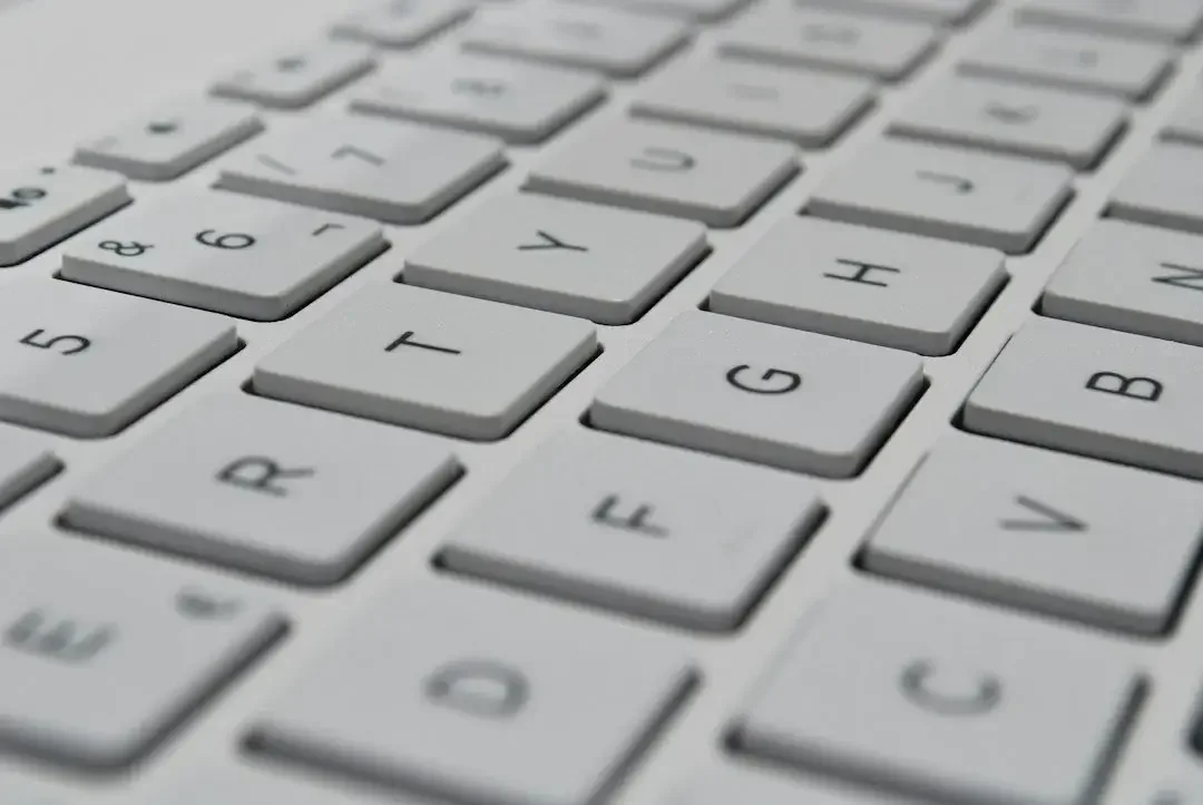 Close-up view of a white computer keyboard with black lettering, showing the keys for the numbers 5, 6, 7, and the letter G and H.