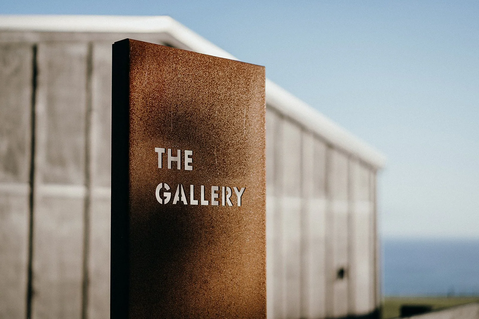 Brown sign reading “The Gallery” outside a modern building