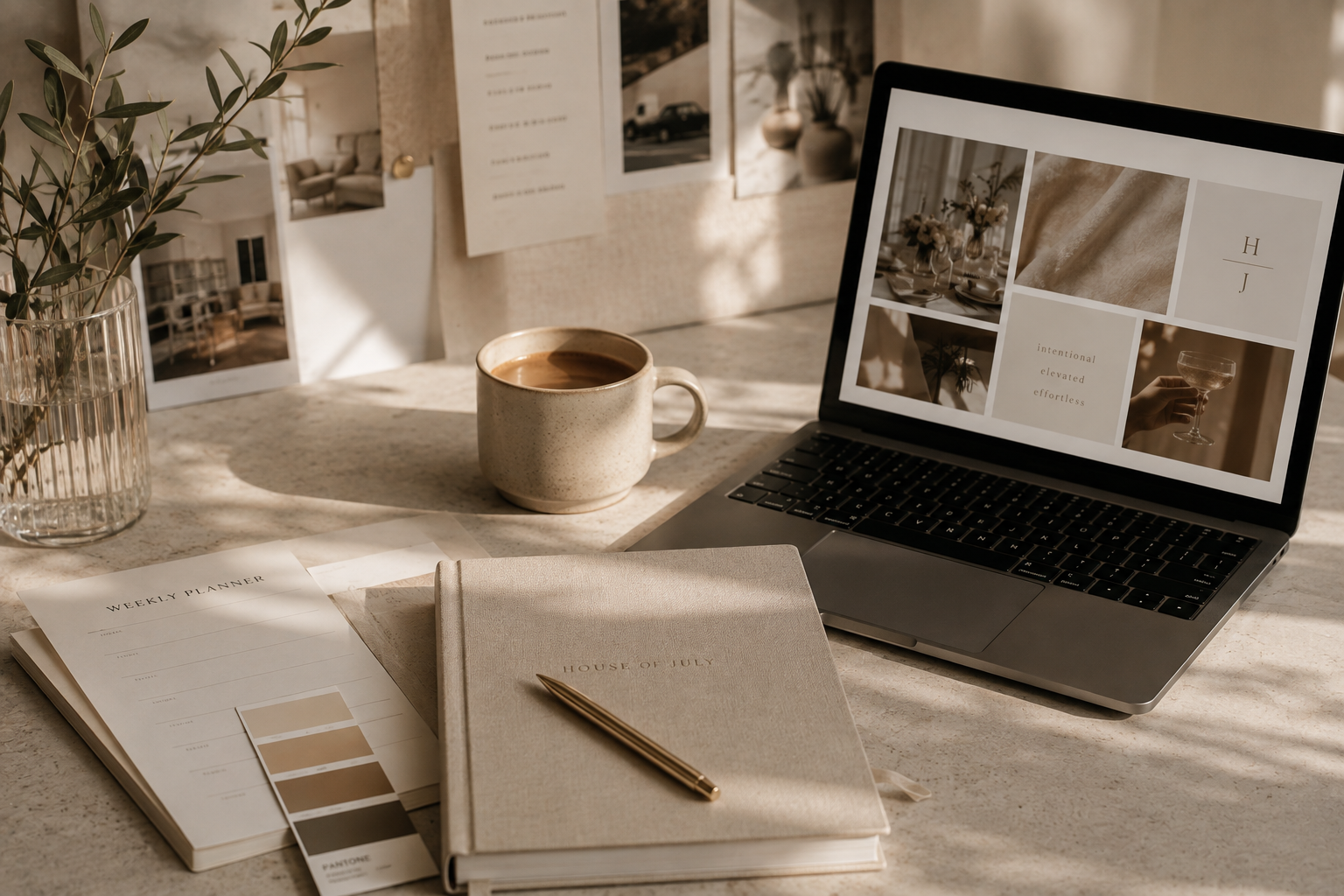 A workspace with a laptop displaying a mood board, a beige planner titled 'House of July', a weekly planner with color swatches, a gold pen, a beige ceramic mug of coffee, a glass vase with greenery, and photos attached to a wall in soft natural light.