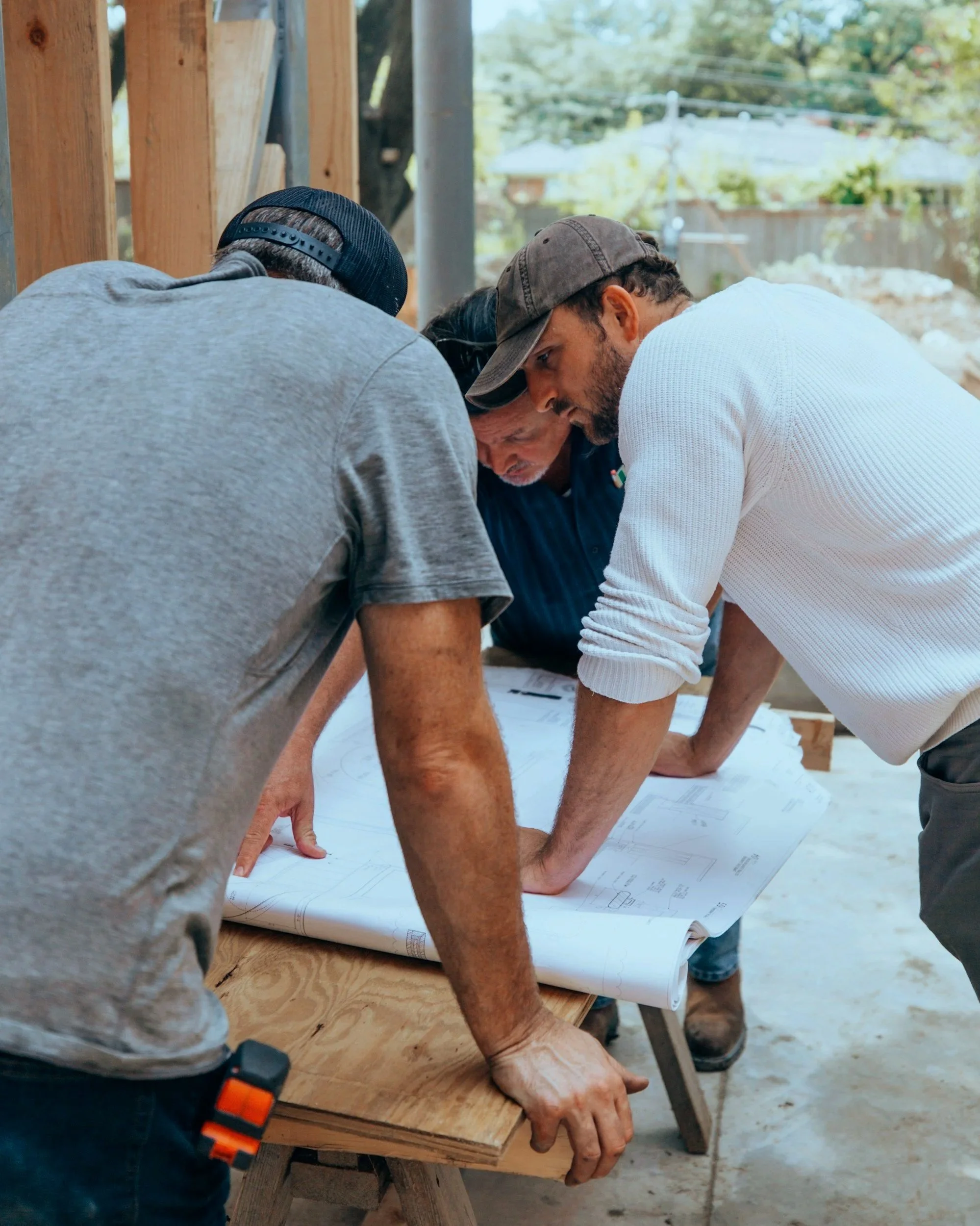 New Zealand builders reviewing construction plans together for accurate project takeoffs and quoting.