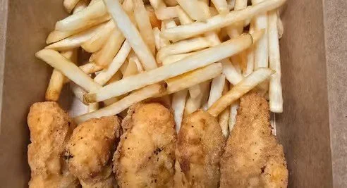 Fried chicken tenders with French fries on a tray.