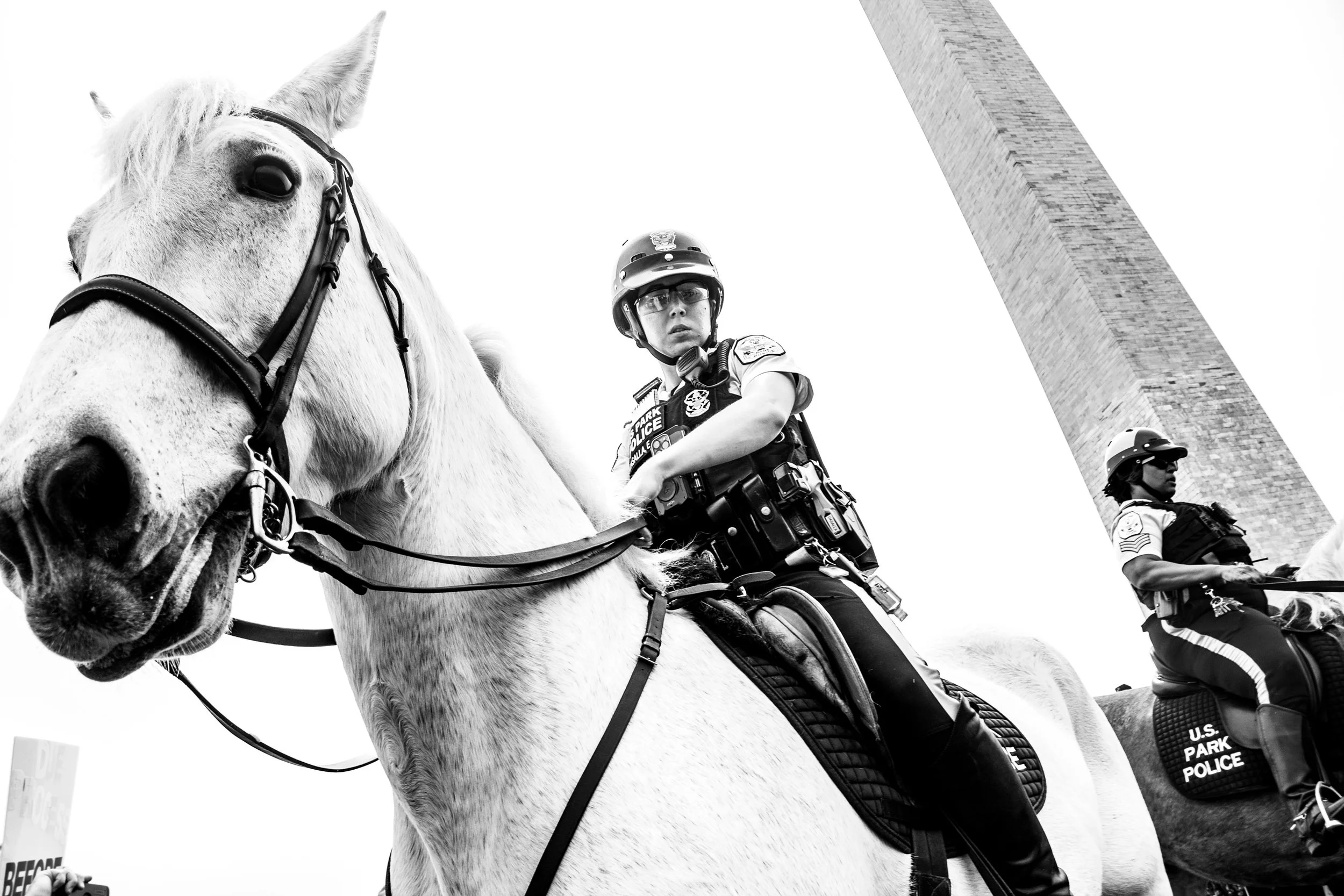 Black and white photo of U.S. Park Police officers on horseback standing near the Washington Monument.