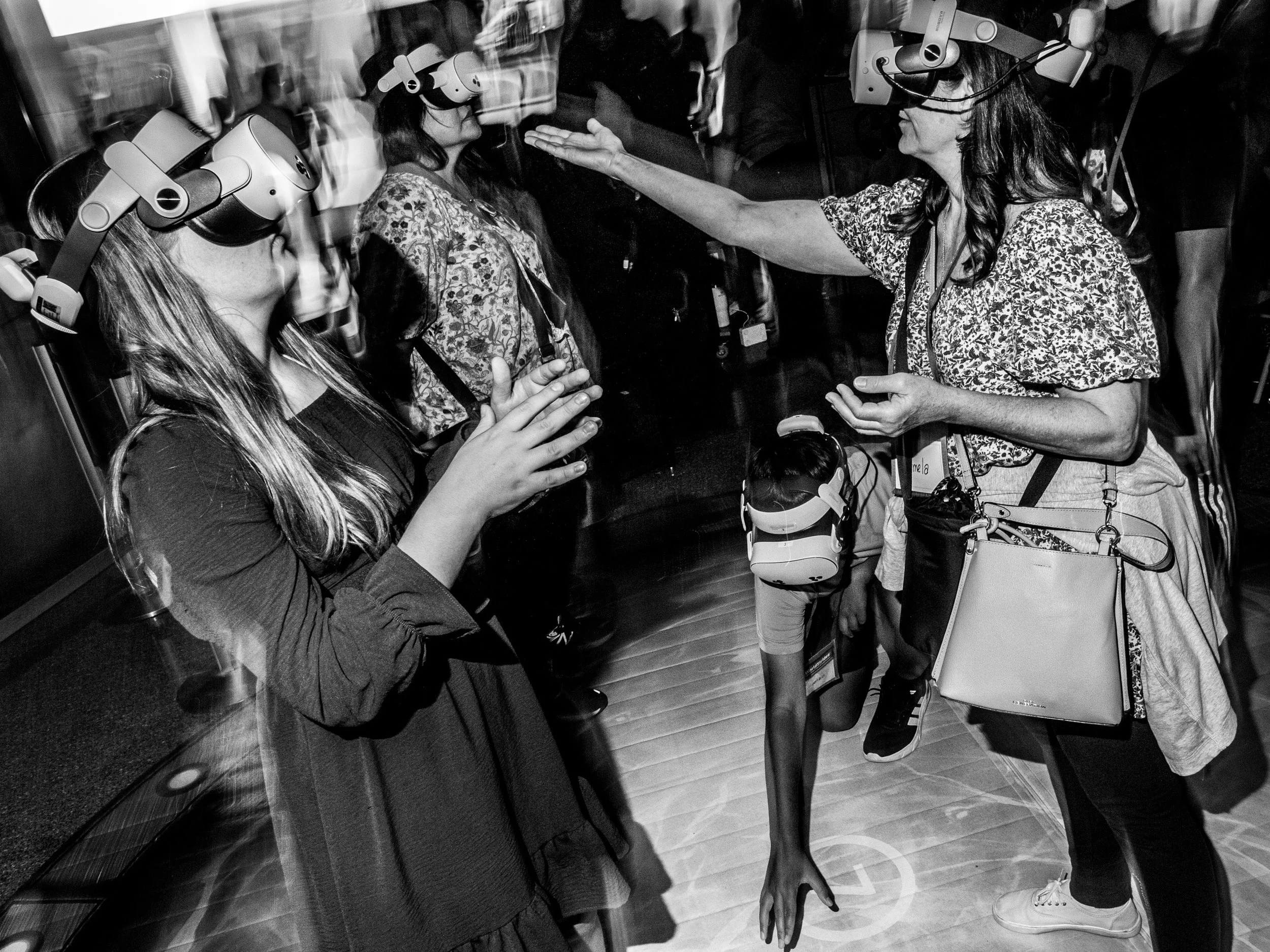 Women wearing virtual reality headsets standing in line.