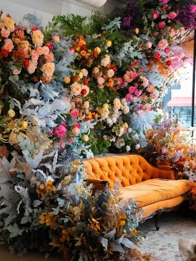 bloom-boom-event-space-orange-velvet-sofa-floral-wall.webp