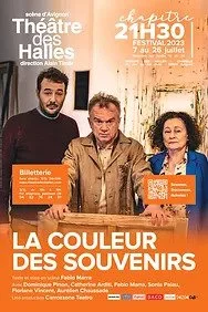 Trois personnes posent devant un panneau annonçant le théâtre, avec du texte en français sur le spectacle 'La Couleur des Souvenirs'.